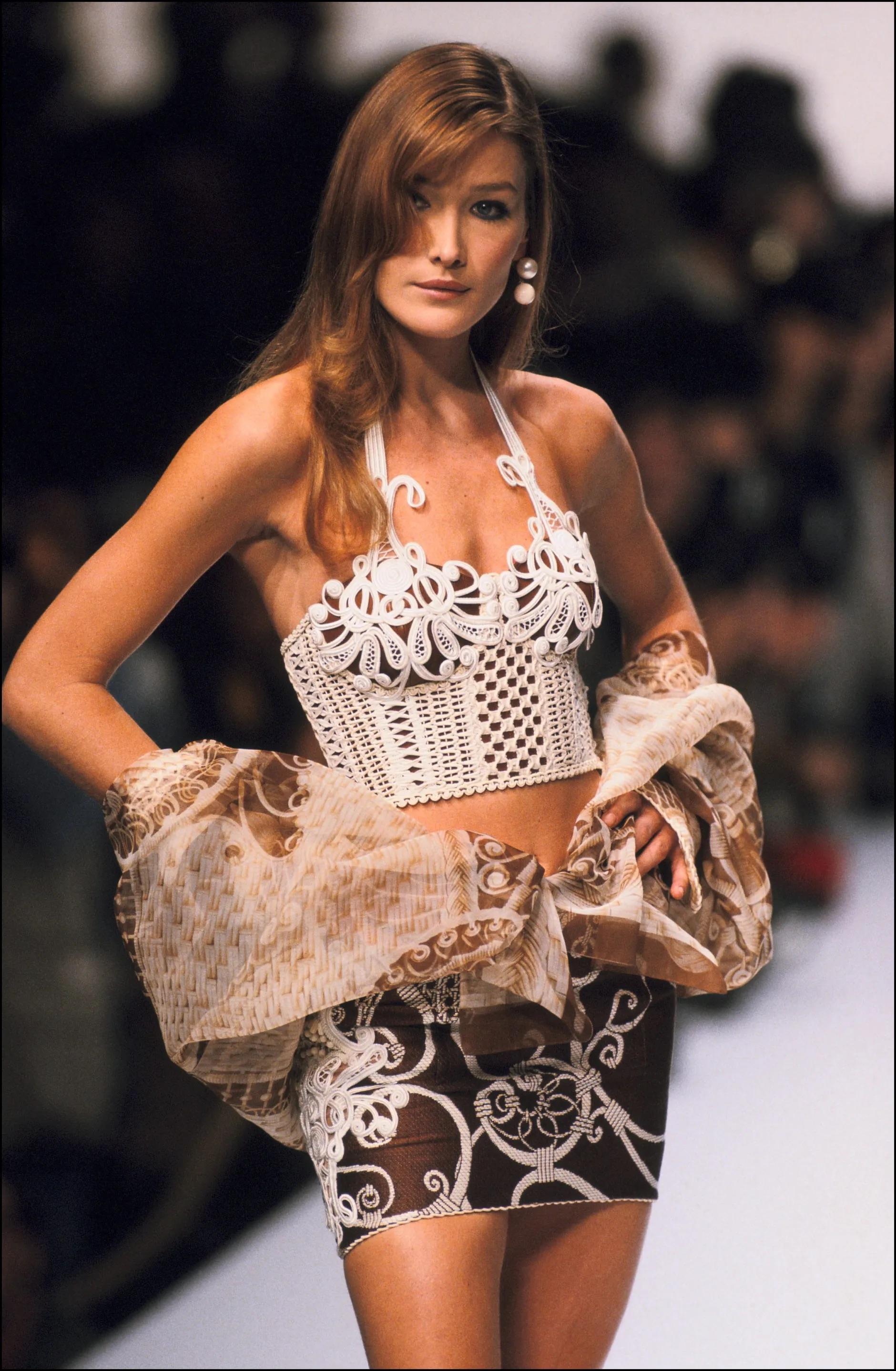 Issue de la collection printemps-été 1995, cette blouse transparente en monogramme de Christian Dior, dessinée par Gianfranco Ferré, a fait ses débuts sur le podium, portée par Carla Bruni. Recouvert d'un motif d'osier déroulant, ce chemisier chic à