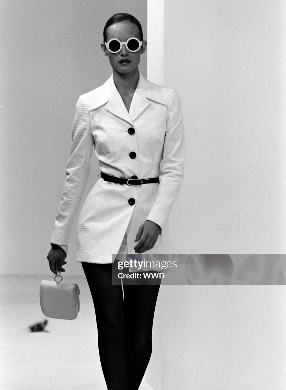 Issue de la collection printemps/été 1995 de Dolce & Gabbana, la version longue de ce tailleur mini-jupe en maille gaufrée blanche a fait ses débuts sur le podium de la saison, portée par Amber Valletta. Ce costume trois pièces comprend un blazer