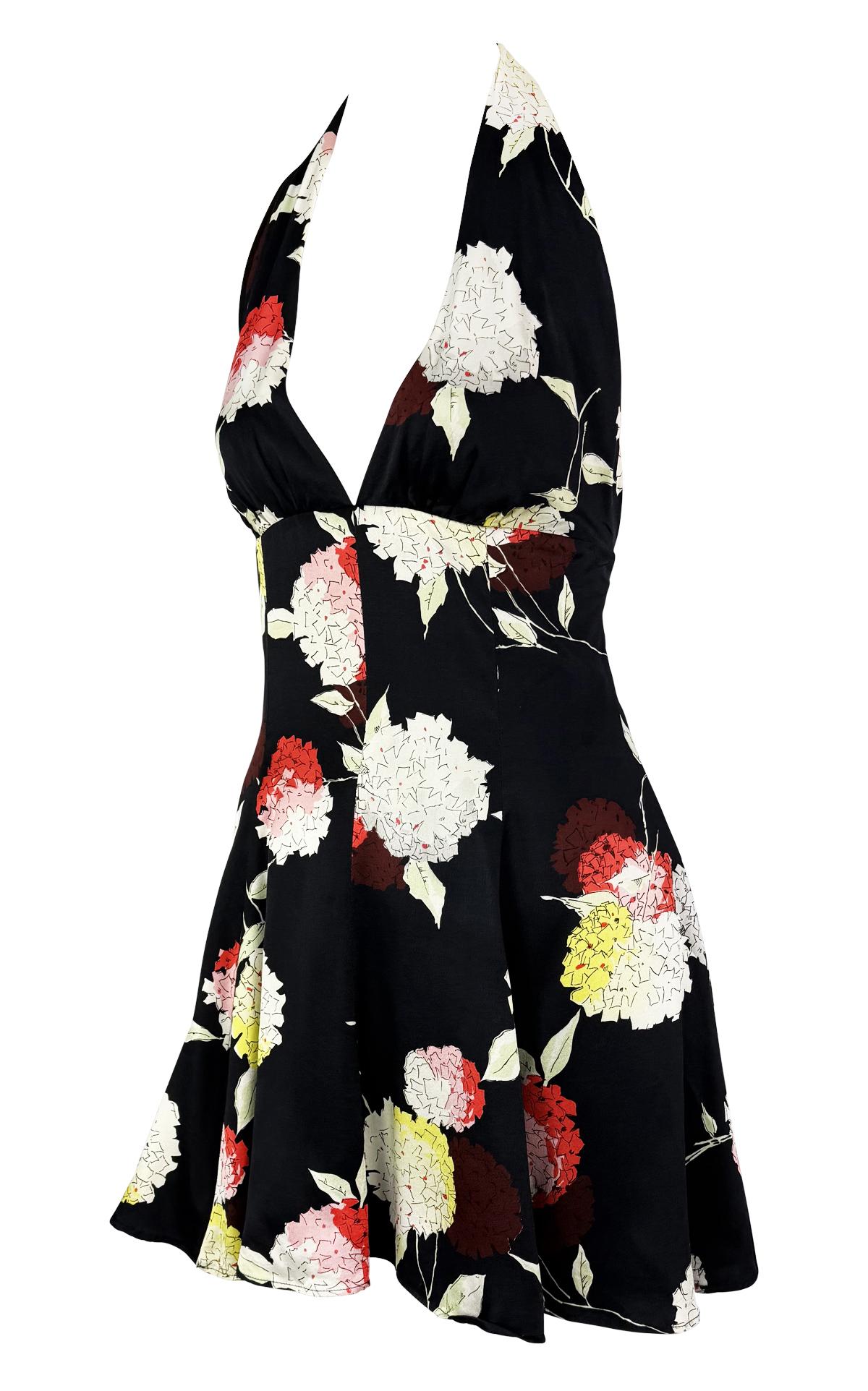From Dolce & Gabbana’s Spring/Summer 1995 collection, this flared halter mini dress features a open back and plunging neckline. Crafted from lightweight silk blend fabric, the dress is adorned with a vibrant hydrangea floral print in soft red,