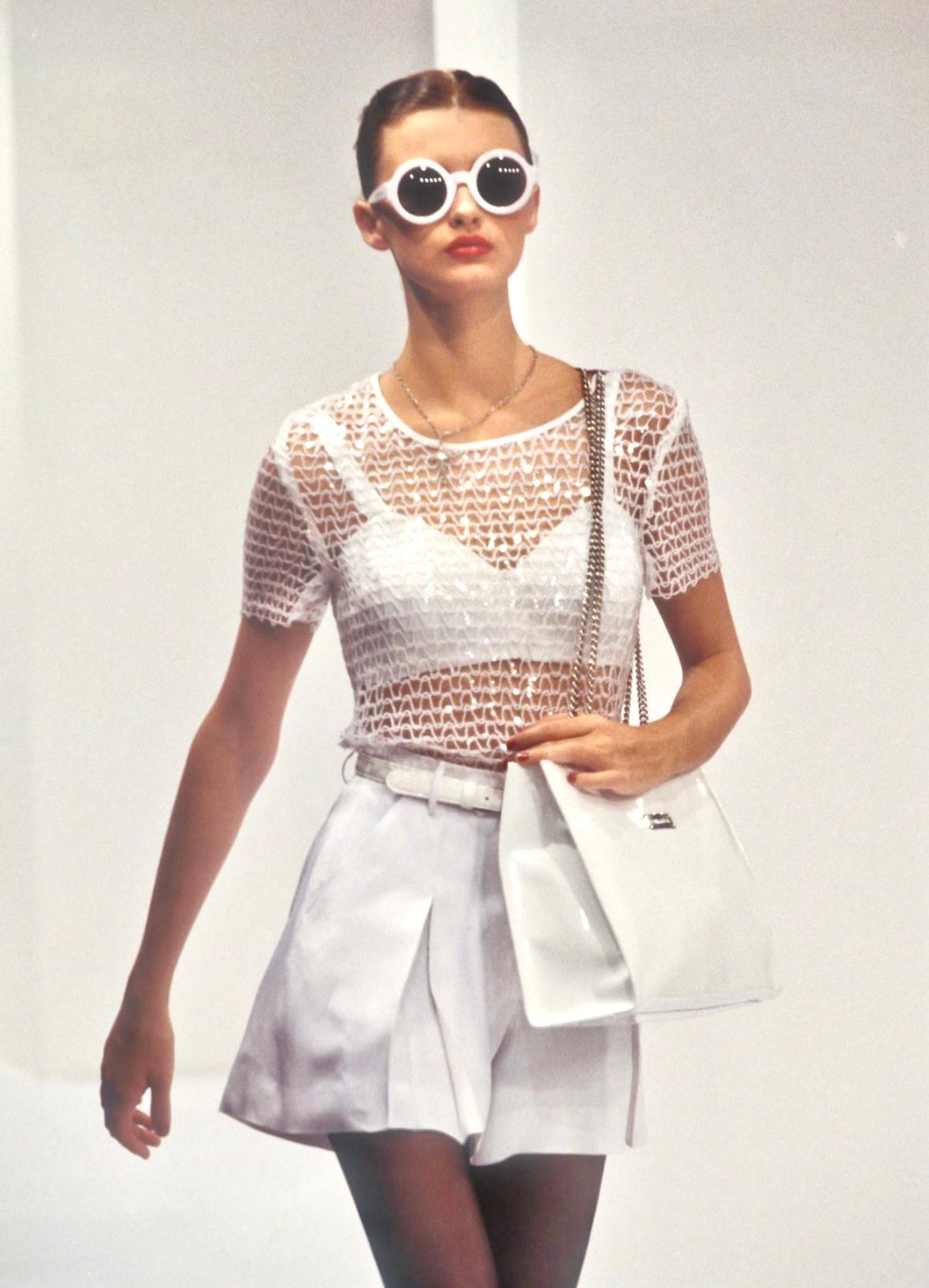 This sheer white knit t-shirt from Dolce & Gabbana's Spring/Summer 1995 collection is embellished with clear sequins throughout. Featured on the season’s runway, the top is designed with a subtle shimmer and a figure-hugging silhouette.

Approximate