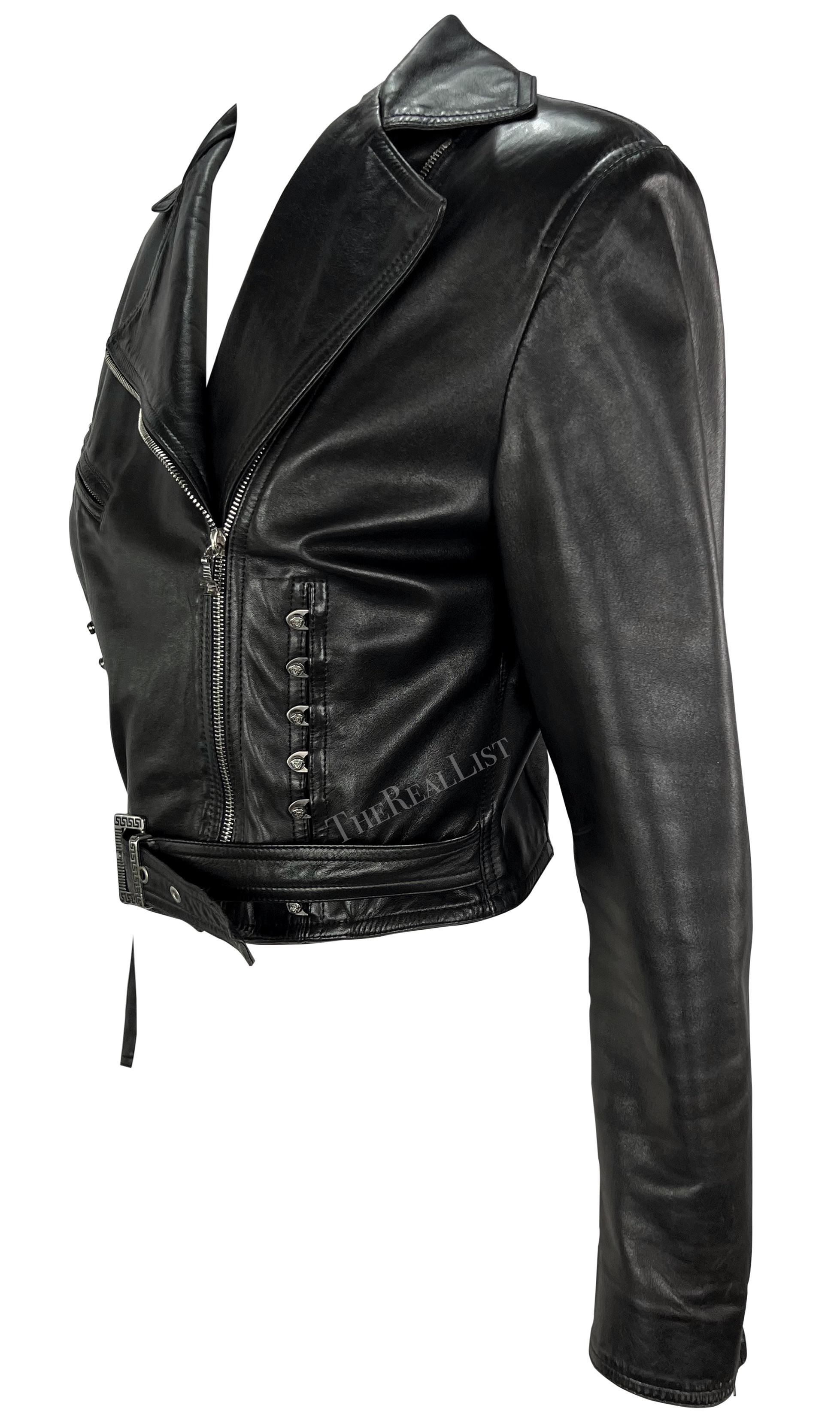 Te presentamos una impresionante cazadora motera de piel negra de Gianni Versace, diseñada por el propio Gianni Versace. Esta pieza chic de la colección Primavera/Verano 1995 es una verdadera encarnación del estilo característico de Versace. La