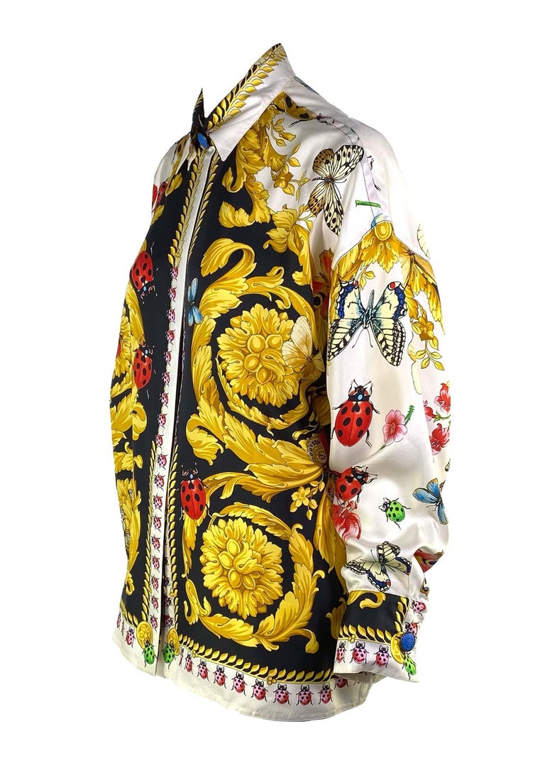 TheRealList presents: a stunning silk Gianni Versace Couture button up shirt, designed by Gianni Versace. Constructed entirely of printed silk, this shirt is covered in the brand's iconic baroque pattern and lady bug/butterfly print. From the