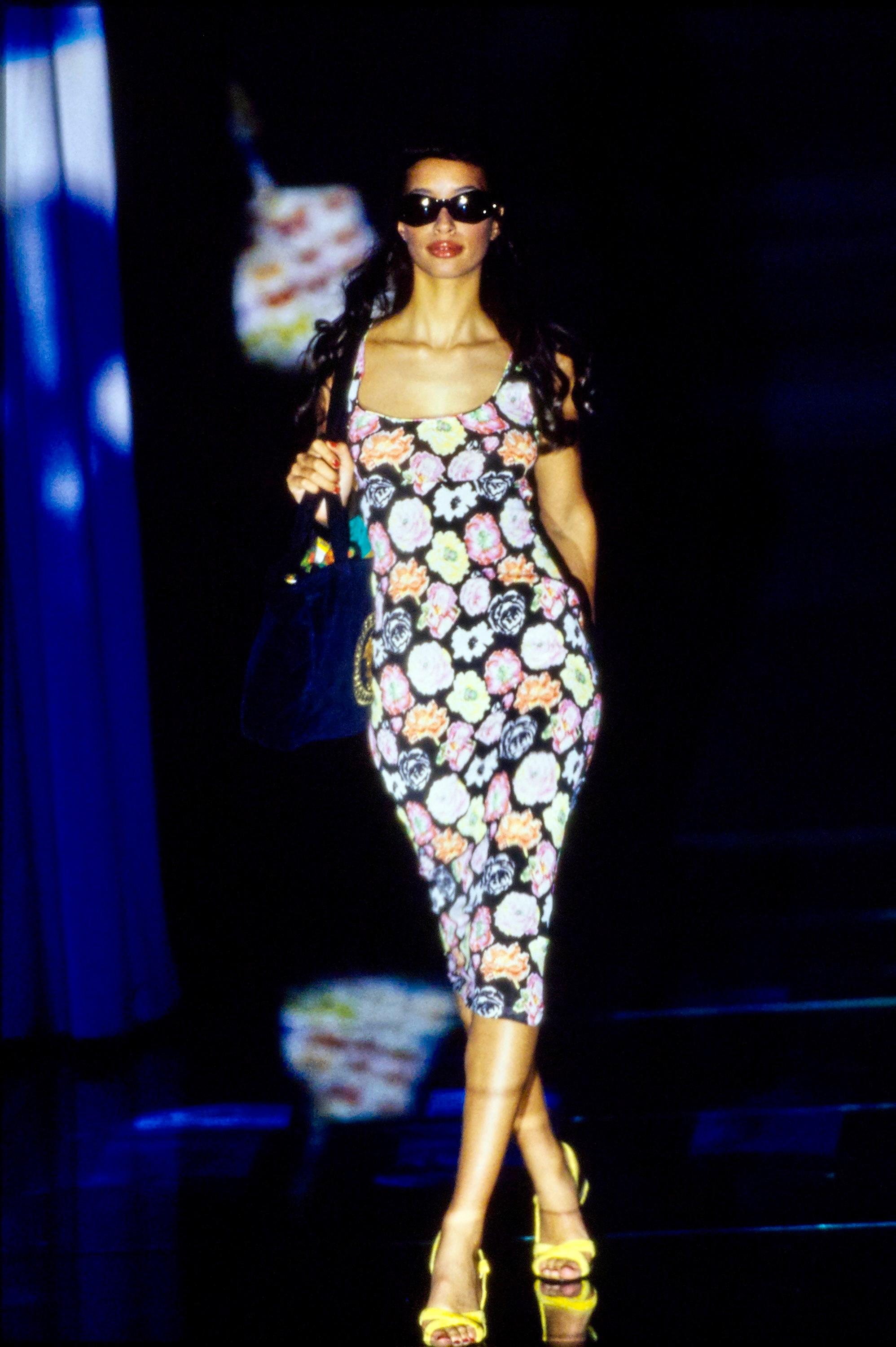Gianni Versace présente une robe extensible semi-transparente à imprimé floral prête à défiler. Cette pièce a fait ses débuts sur Brandi Quinones lors du look 11 de la présentation du défilé S/S 1995. Gianni a décrit cette collection comme 