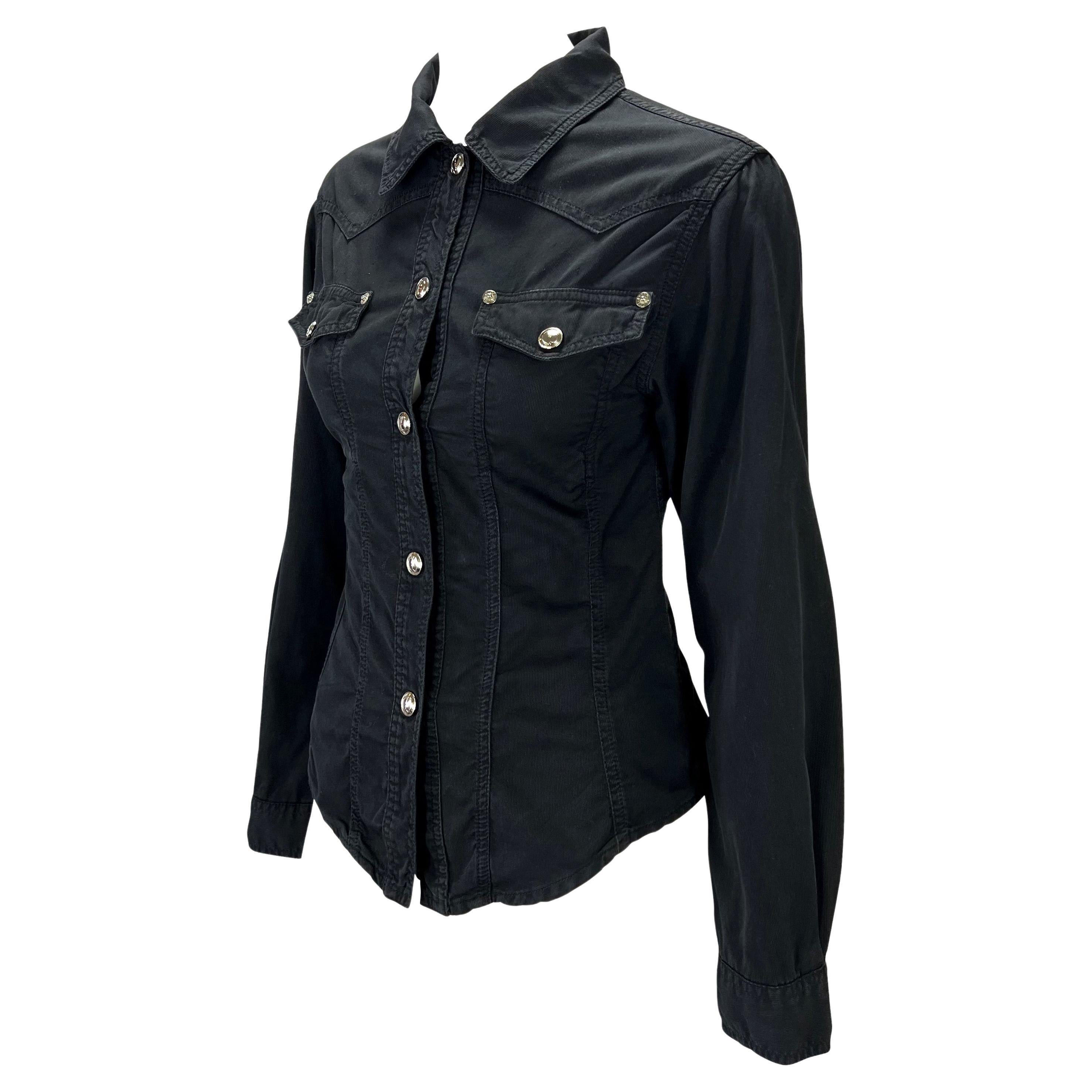Ti presentiamo un top nero in twill affusolato di Gucci, disegnato da Tom Ford. Dalla collezione primavera/estate 1995, questo top è caratterizzato da un classico stile camicia button-down arricchito da due tasche sul busto e da chiusure a scatto