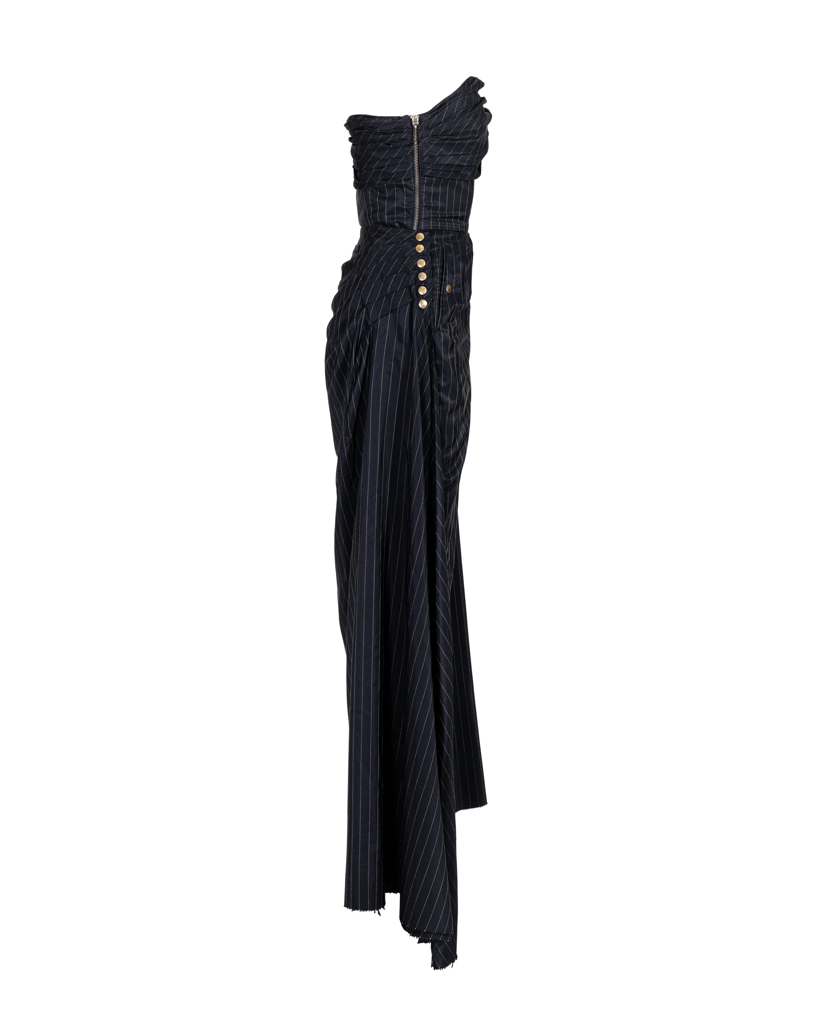 S/S 1995 Jean Paul Gaultier pinstripe strapless bustle gown with gold-tone studded details at sides. Strapless striped dress with fitted waist and asymmetrical gathered bust and hip. Built-in corset with boning. Visible side bronze zip closure, with