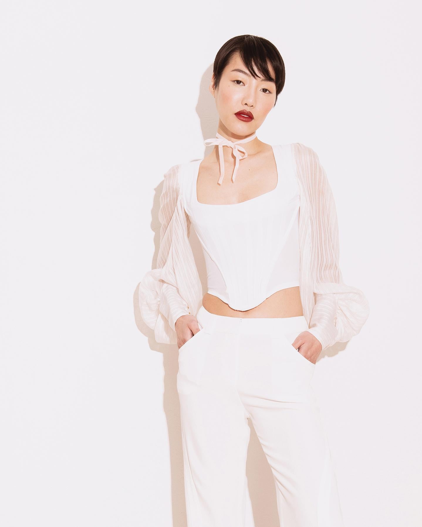 S/S 1995 Vivienne Westwood white bishop sleeve corset top with boning. White built-in boning corset bodice front with striped semi-sheer bishop sleeves, featuring three gold Westwood signature 'orb' closures at wrists. Back zip closure. Note: this