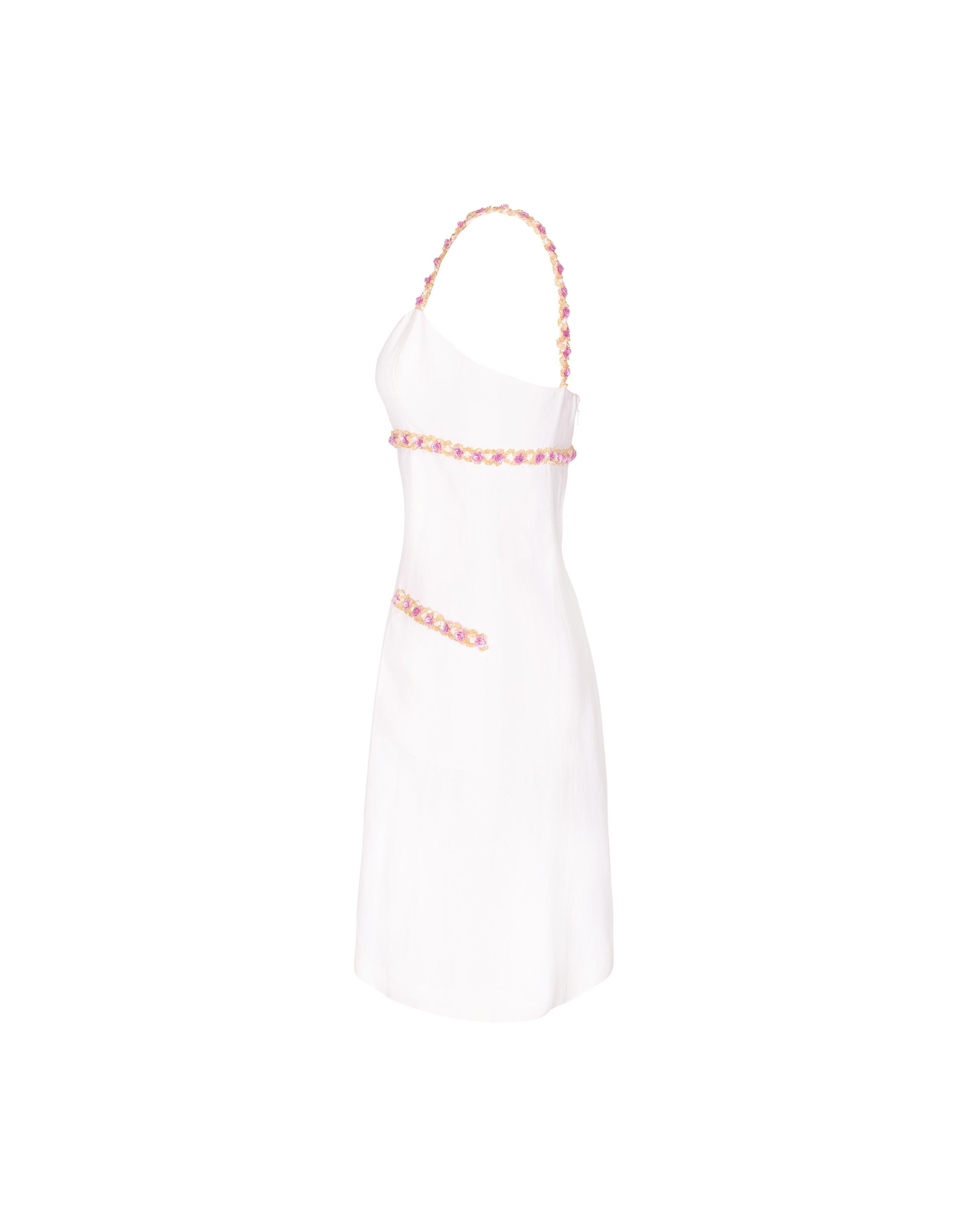 S/S 1996 Chanel by Karl Lagerfeld white linen mini dress with 3D pink floral trim. Ecru mini dress with functional front flap pockets and concealed back zip closure. Features pink and yellow-gold sequin flower trim at straps, under bust, and