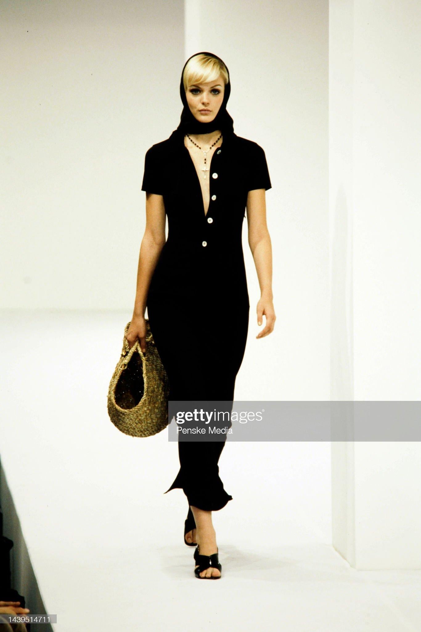 Presenting a stunning black Dolce & Gabbana short sleeve collared gown. From the Spring/Summer 1996 collection, this chic dress debuted on the season's runway. This refined dress features short sleeves and a fold-over collar. The dress is defined by