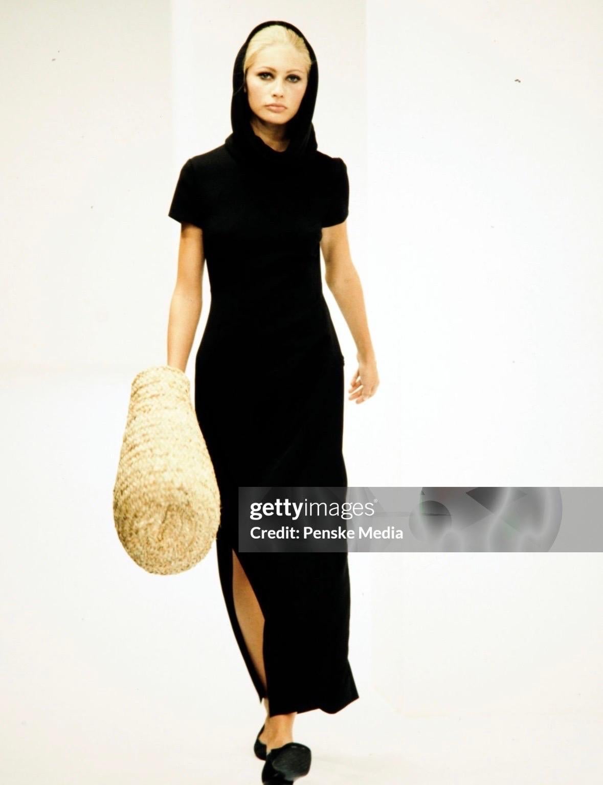 Dieses wunderschöne schwarze Maxikleid von Dolce & Gabbana aus der Frühjahr/Sommer-Kollektion 1996 wurde auf dem Laufsteg der Saison von Kirsty Hume präsentiert. Dieses fast bodenlange Kleid hat kurze Ärmel, hohe Schlitze an beiden Seiten und einen