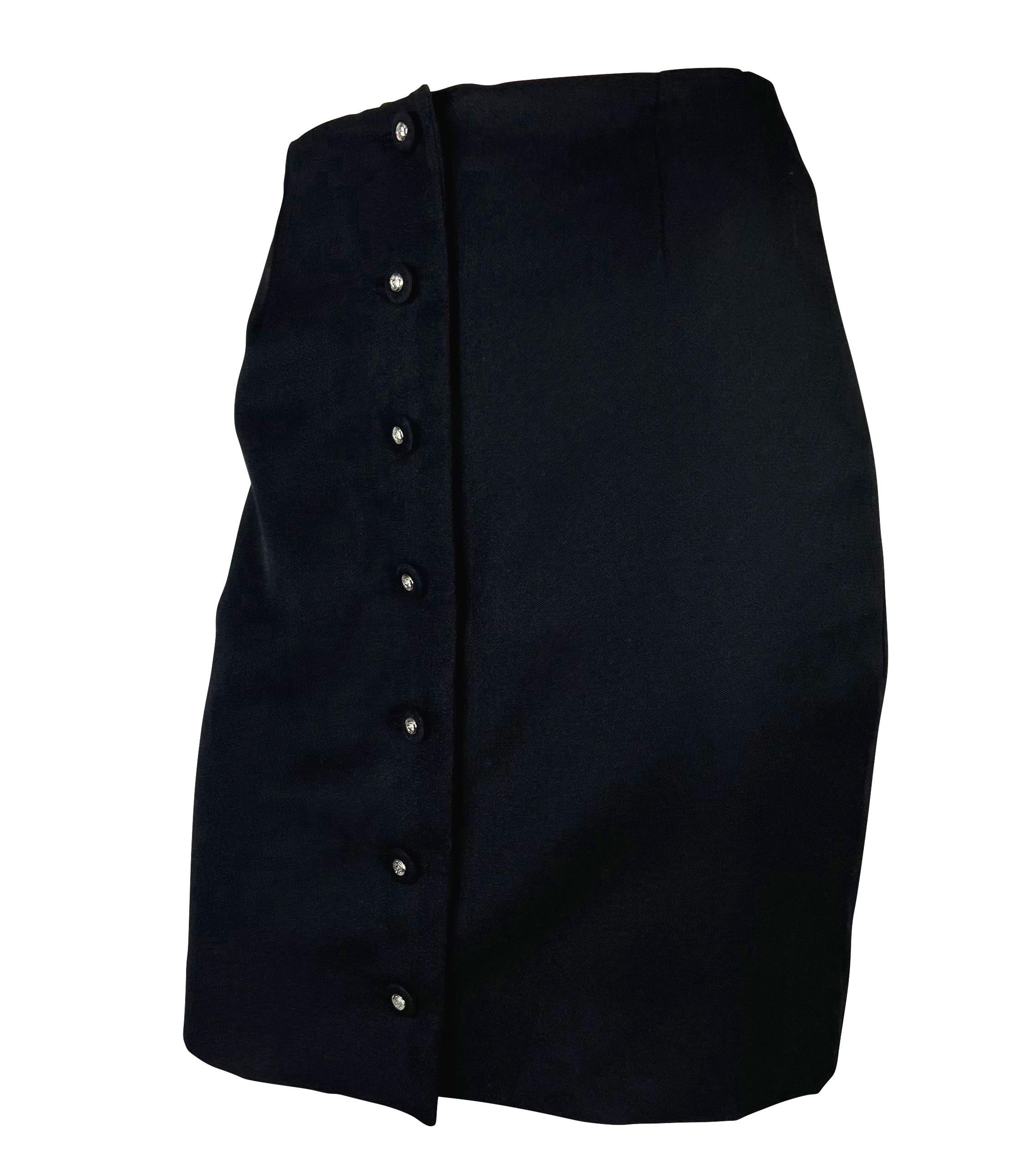 Voici une jupe crayon en laine stretch noire Gianni Versace, conçue par Gianni Versace. Issue de la collection printemps/été 1996, cette magnifique jupe noire est agrémentée d'une rangée de boutons médusa de Versace recouverts d'étoffe et de