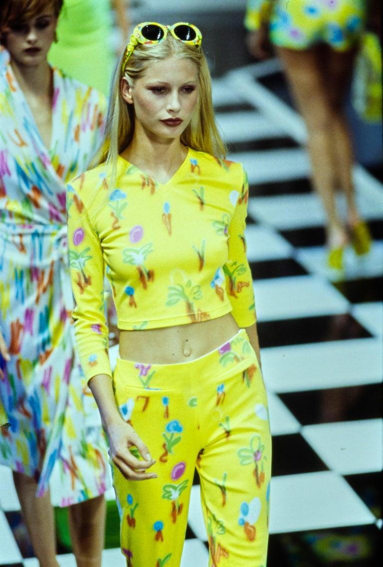 Wir präsentieren einen leuchtenden, neonfarbenen Gianni Versace Couture-Rock, entworfen von Gianni Versace. Dieser florale Graffiti-Druck aus der Frühjahr/Sommer-Kollektion 1996 wurde erstmals auf dem Laufsteg bei Look 80 von Kirsty Hume gezeigt.