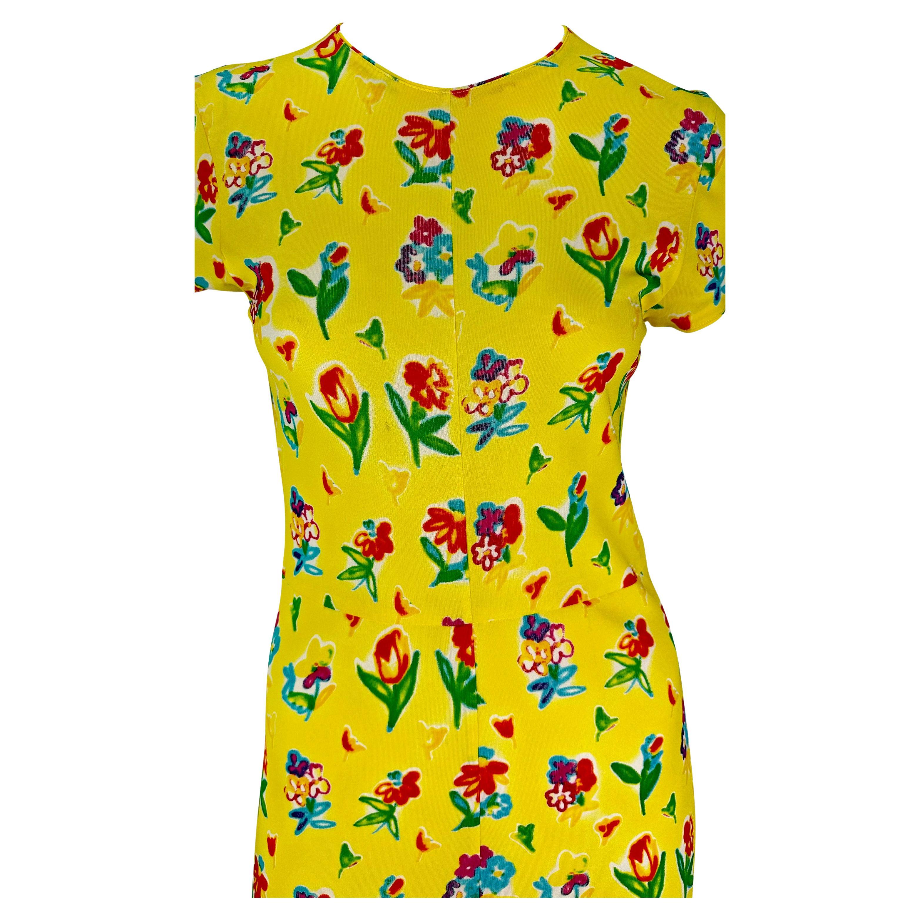 Voici une magnifique robe midi Gianni Versace à fleurs jaunes, conçue par Gianni Versace. Issue de la collection printemps/été 1996, cette robe jaune très féminine est recouverte d'un motif floral coloré peint à la bombe. La robe est composée d'une