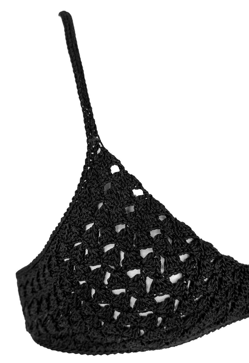 From Gucci’s Spring/Summer 1996 collection by Tom Ford, this delicate bralette is crafted from black crochet cotton, showcasing a sheer, open-knit design. Slender straps cross elegantly at the back, fastened by a signature silver-tone 'GG' logo