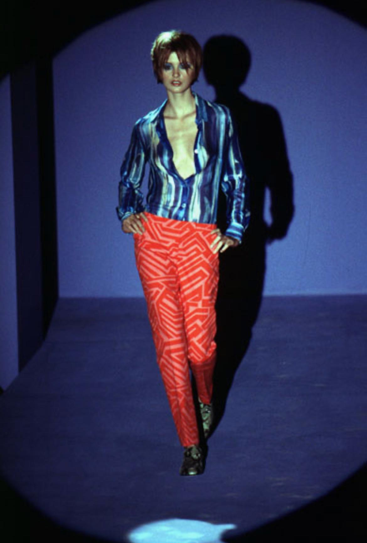 Ich präsentiere eine rote Hose mit abstraktem Muster von Gucci by Tom Ford. Diese Hose aus der Frühjahr/Sommer-Kollektion 1996 wurde erstmals auf dem Laufsteg präsentiert und war auch in der Werbekampagne der Saison zu sehen, die von Mario Testino