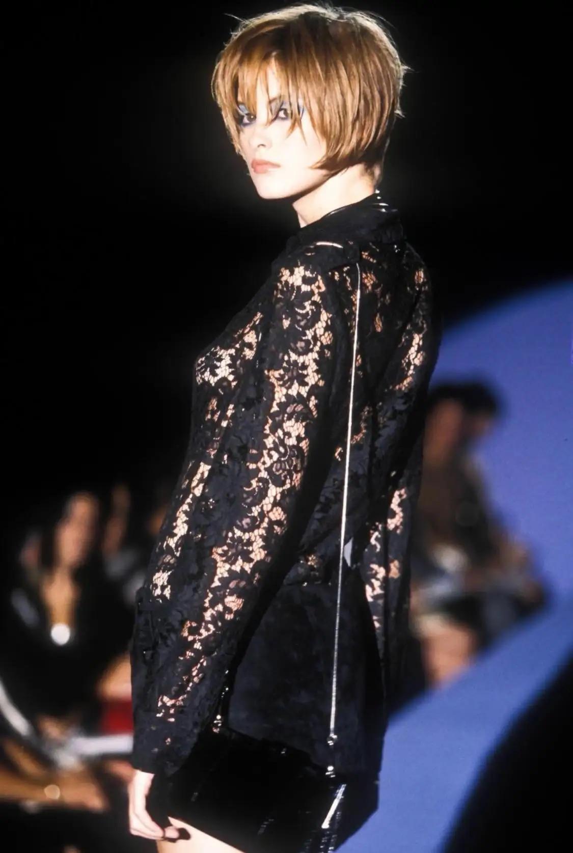 Wir präsentieren ein von Tom Ford entworfenes Gucci-Oberteil aus schwarzer Spitze mit Knöpfen. Dieses Oberteil aus der Frühjahr/Sommer-Kollektion 1996 wurde erstmals auf dem Laufsteg der Saison und in der Januar-Ausgabe 1996 der US Vogue mit Trish