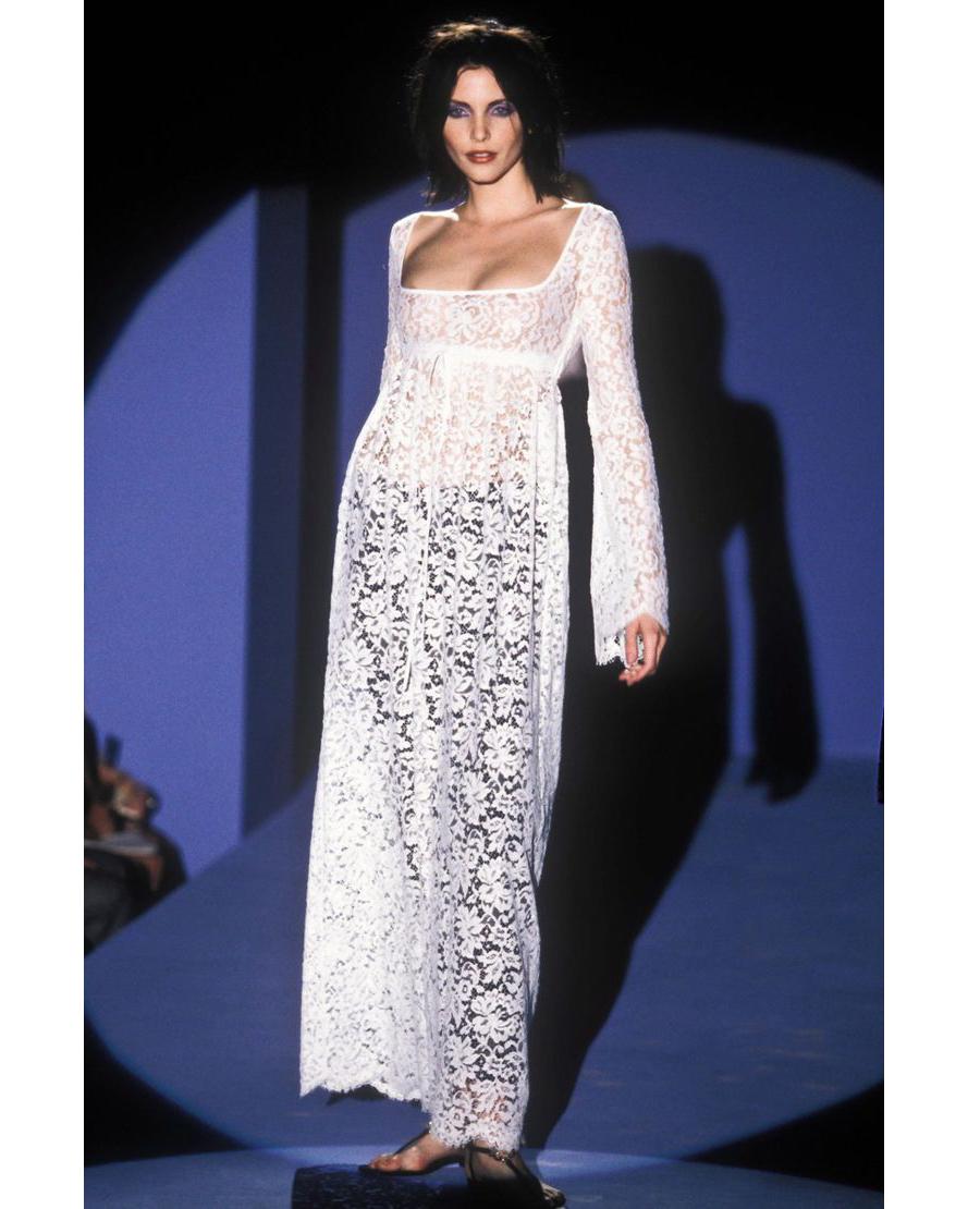 S/S 1996 Gucci by Tom Ford white lace long sleeve empire waist gown with nude lining. Scoop neck gown with long white lace bell sleeves, with nude silk sleeveless lining that ends slightly before lace hemline. Features small tie closure at waist,