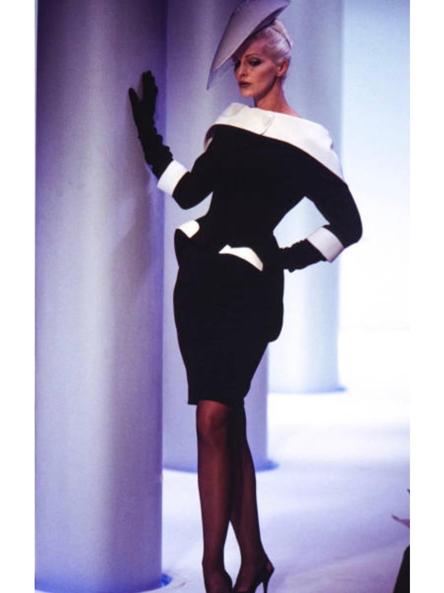 Possédez un morceau d'histoire de la mode avec cet extraordinaire tailleur jupe documenté de Thierry Mugler printemps-été 1996. Veste noire et blanche avec un grand col Foldes et un grand bouton blanc sur le col. Forme classique Mugler avec hanches