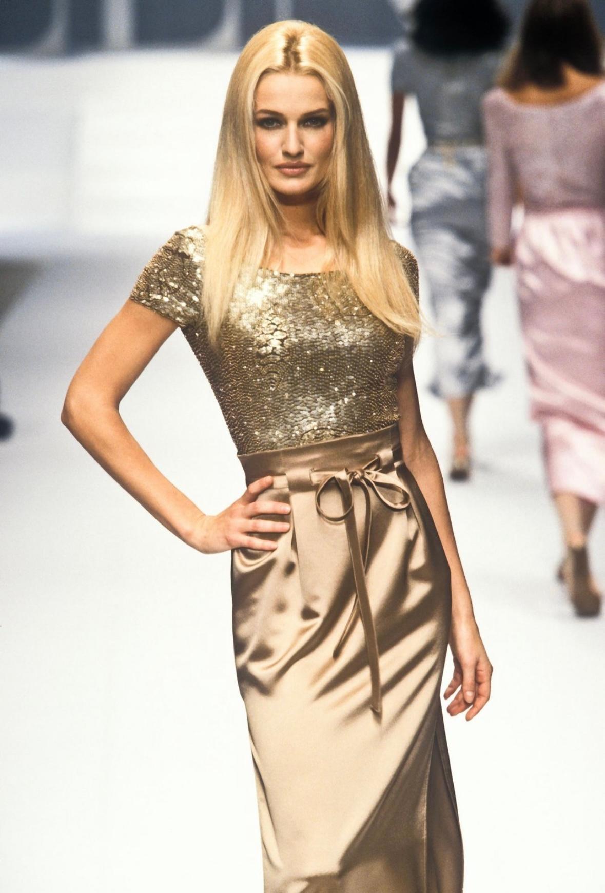 Presenting an incredible gold Valentino beaded skirt set. From the Spring/Summer 1996 collection, this two-piece set debuted on the season's runway on Karen Mulder. This two-piece set consists of a beaded body suit and a matching high-waisted skirt.