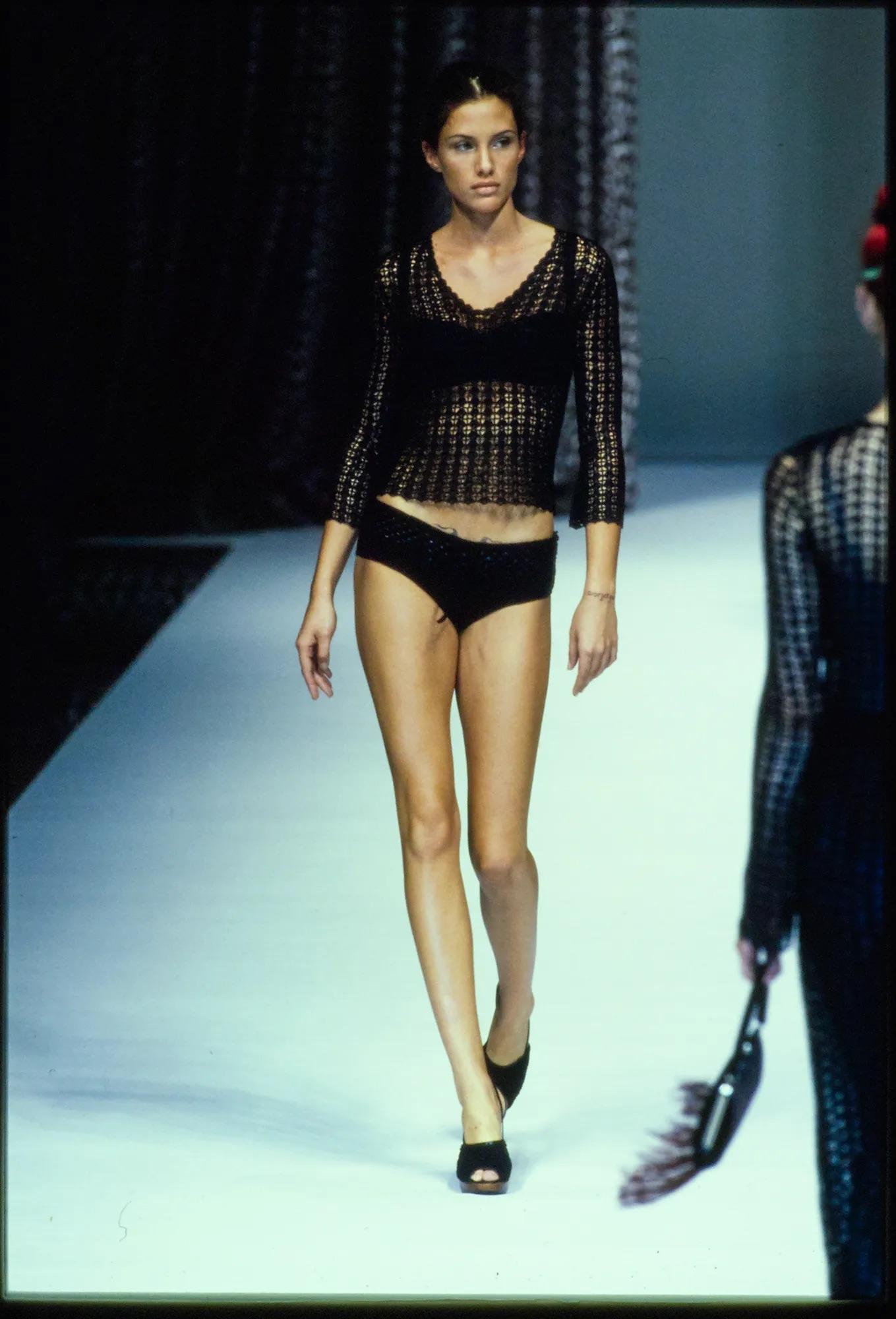 Je vous présente un magnifique top Dolce & Gabbana en crochet noir. Issu de la collection printemps/été 1997, ce haut a été présenté dans une variante de ce motif au point de crochet dans le look 9 du défilé de la saison. Ce haut présente une