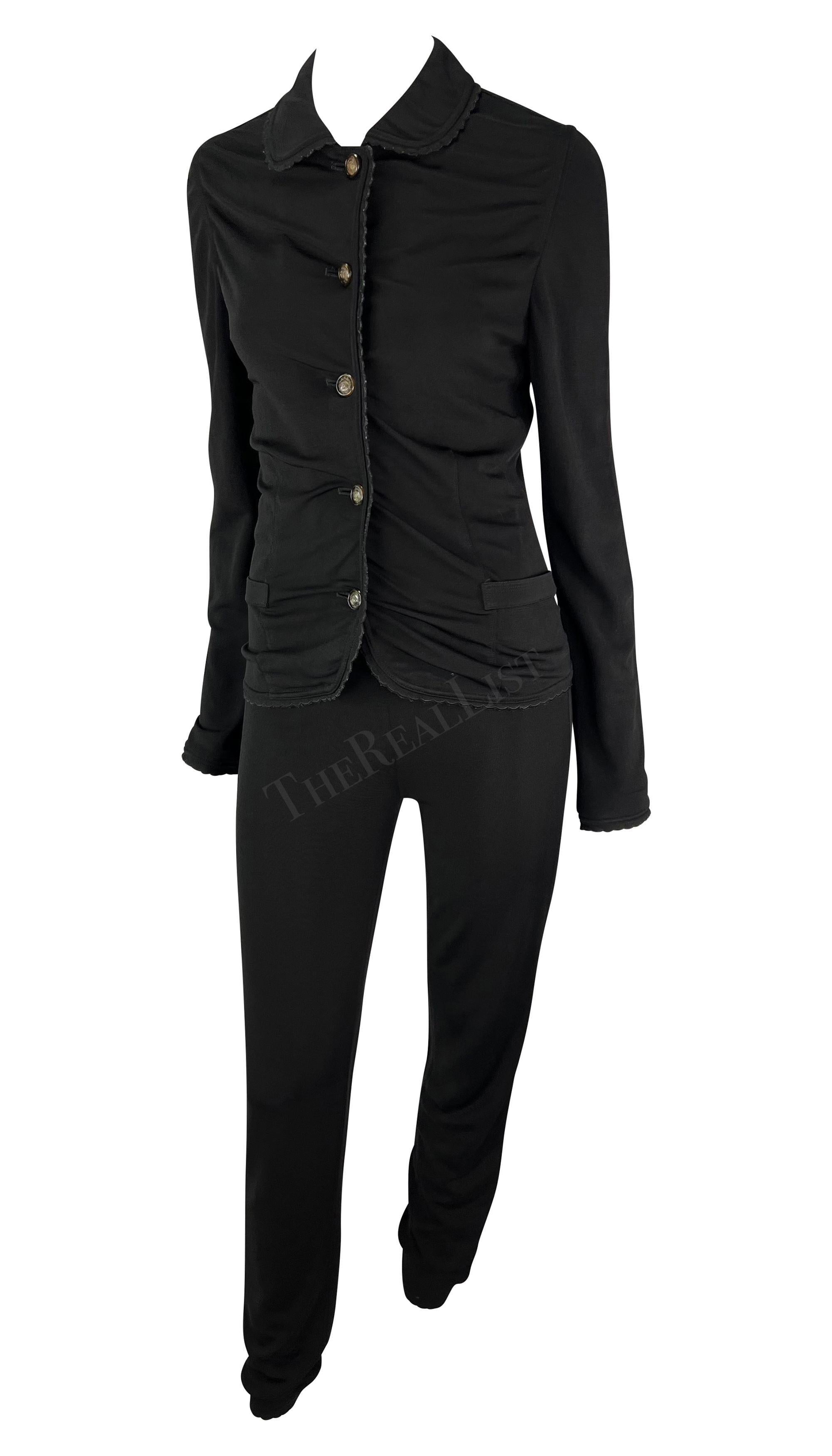Ti presentiamo un favoloso set di maglioni Gianni Versace in maglia nera, disegnato da Gianni Versace. Dalla collezione 1997, questo set nero elasticizzato è composto da un paio di pantaloni aderenti e da un cardigan abbinato. I pantaloni sono a