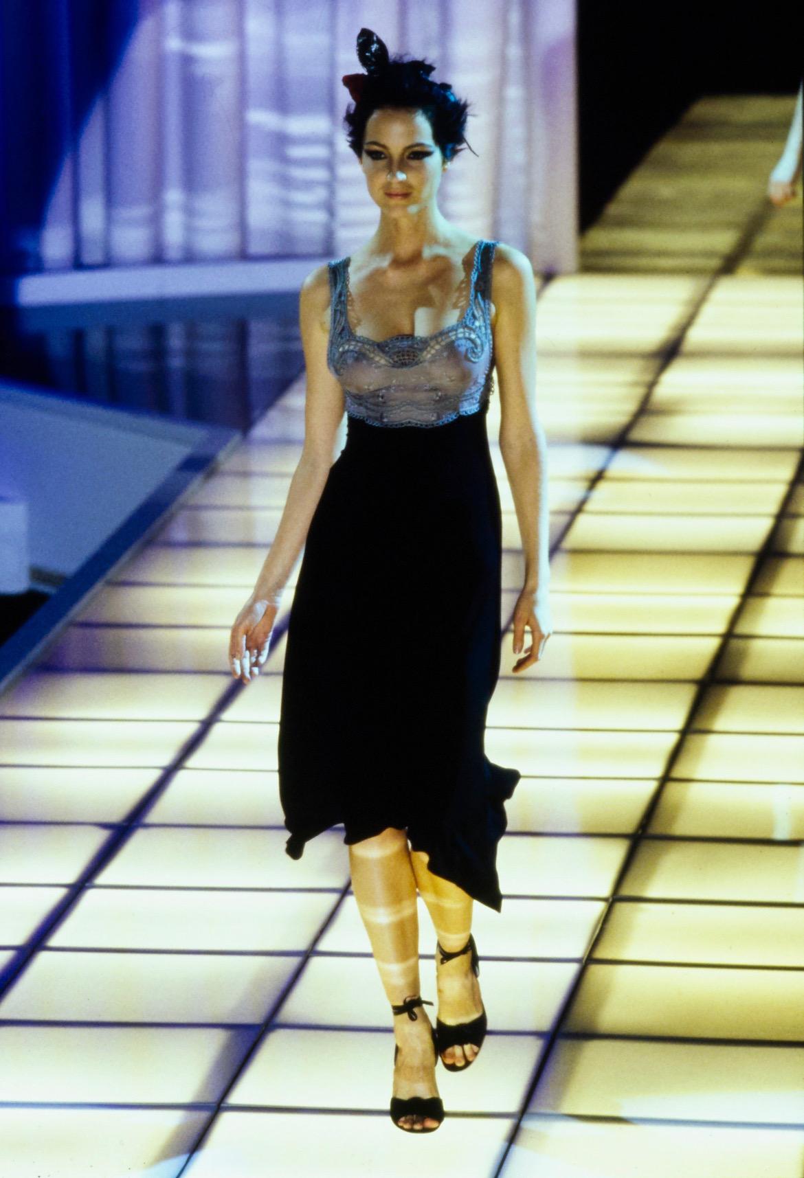 Voici une magnifique robe en dentelle Gianni Versace Couture, dessinée par Gianni Versace. Issue de la collection printemps/été 1997, cette robe a fait ses débuts sur le podium de la saison en tant que look numéro 76 porté par Chandra North. Cette