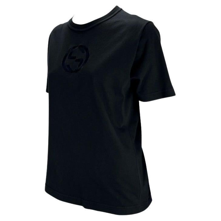 Wir präsentieren ein schwarzes Gucci-T-Shirt im Vintage-Stil, entworfen von Tom Ford. Dieses klassische schwarze T-Shirt aus der Frühjahr/Sommer-Kollektion 1997 ist mit einem großen gestickten, ineinandergreifenden Gucci-Logo 