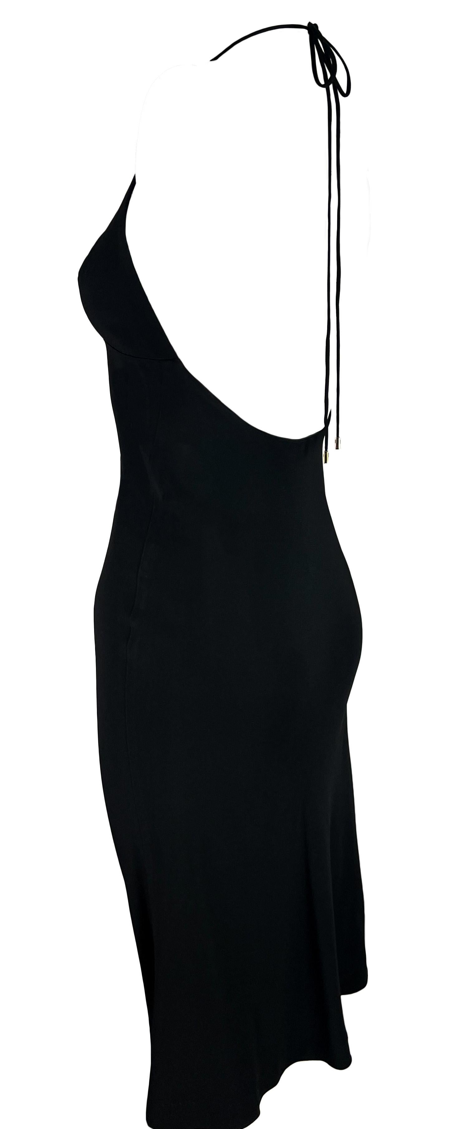 This black Gucci halter neck dress, from the Spring/Summer 1997 collection, is designed by Tom Ford. It features a V-neckline, spaghetti straps, and an exposed back. Gold-tone metal accents at the tips of the halter neck ties complete this chic
