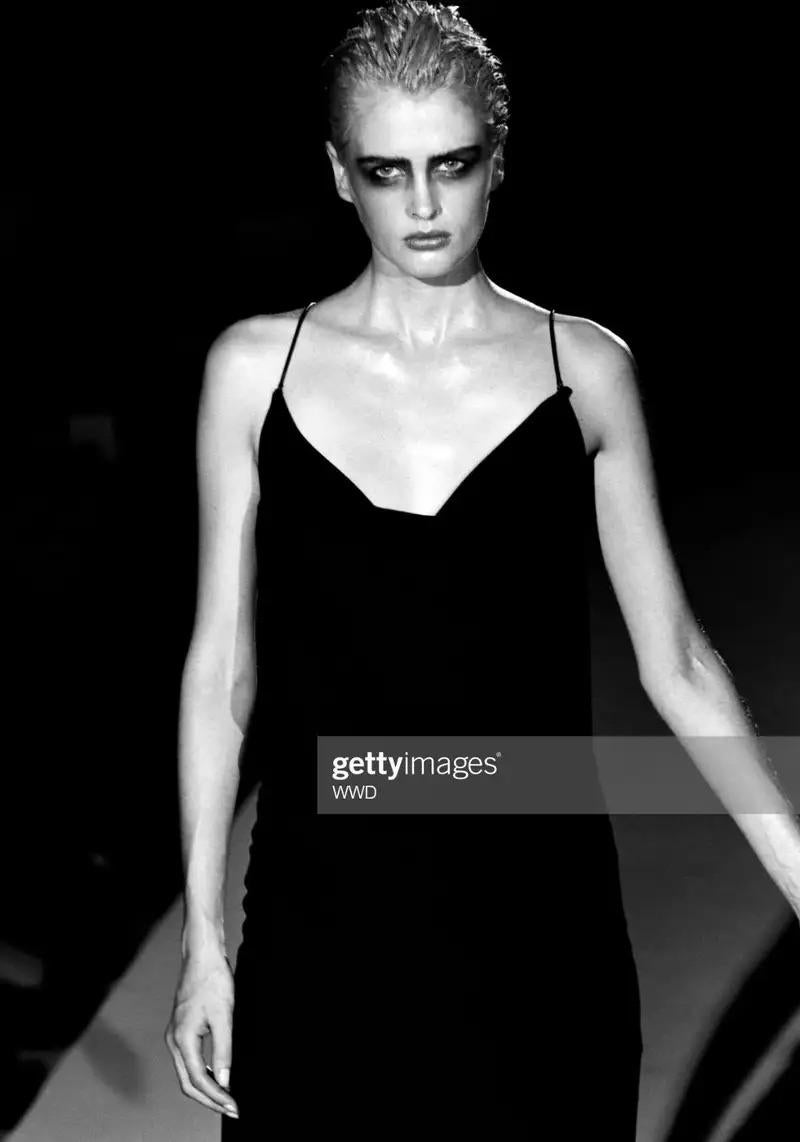 Presenting a stunning black Gucci slip gown, designed by Tom Ford for the Spring/Summer 1997 collection. This sultry floor-length gown features spaghetti straps and is elegantly draped with a cowl neckline at the bust and back, highlighted