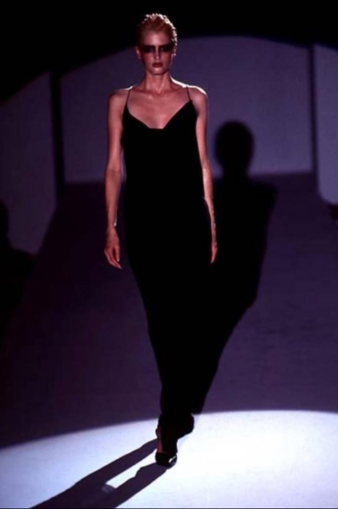 Ich präsentiere ein umwerfendes schwarzes Gucci-Slipkleid, entworfen von Tom Ford. Dieses schwüle, bodenlange Kleid mit Spaghetti-Trägern stammt aus der Frühjahr/Sommer-Kollektion 1997 und ist im Brust- und Rückenbereich mit einer Kutte drapiert.