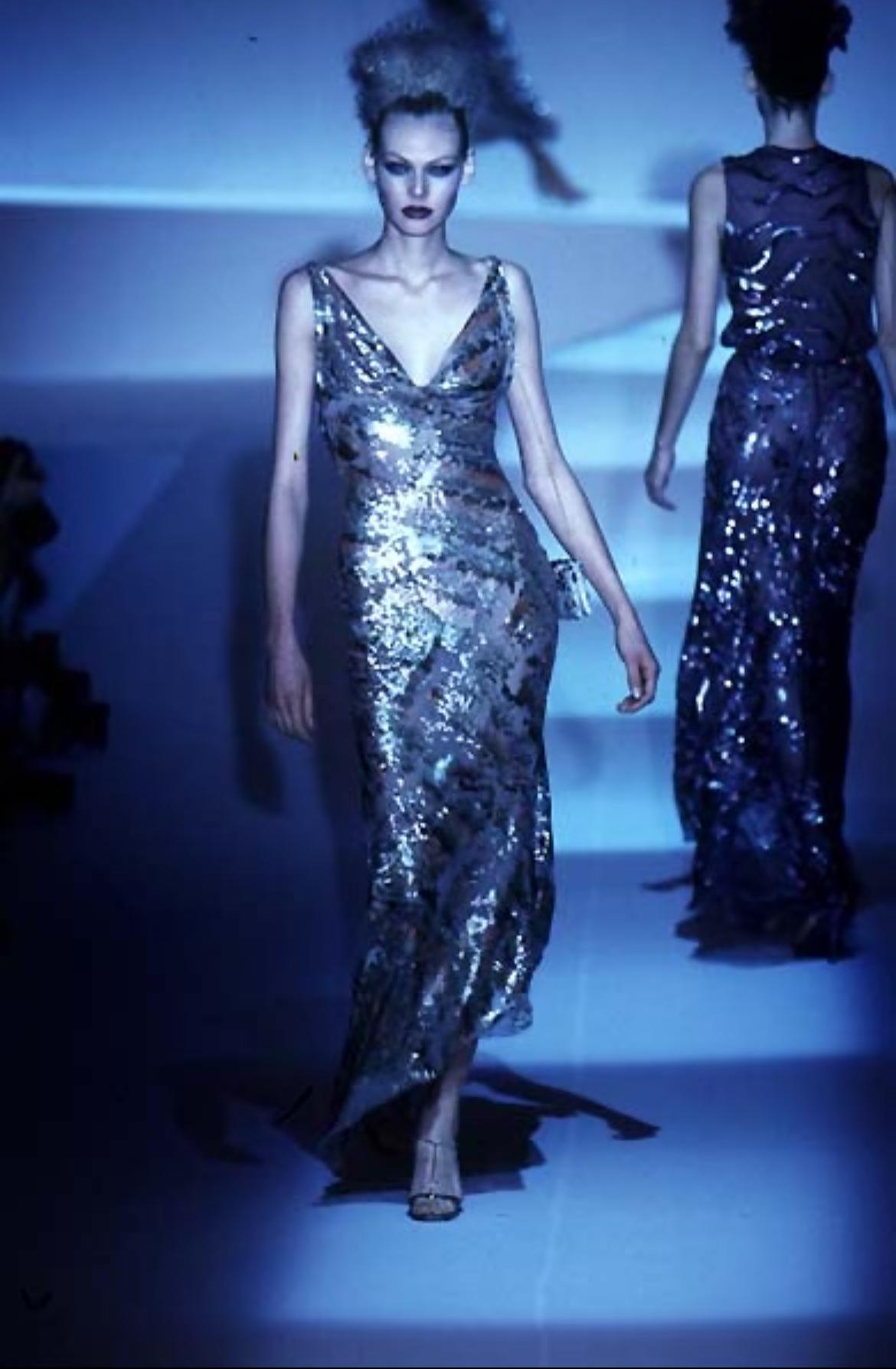 This stunning gold sequin Valentino gown debuted on the Spring/Summer 1997 season's runway. This sexy gown features a plunging cowl neckline, an exposed back with a cowl design at the lower back, and an asymmetrical hem with a small train. The dress