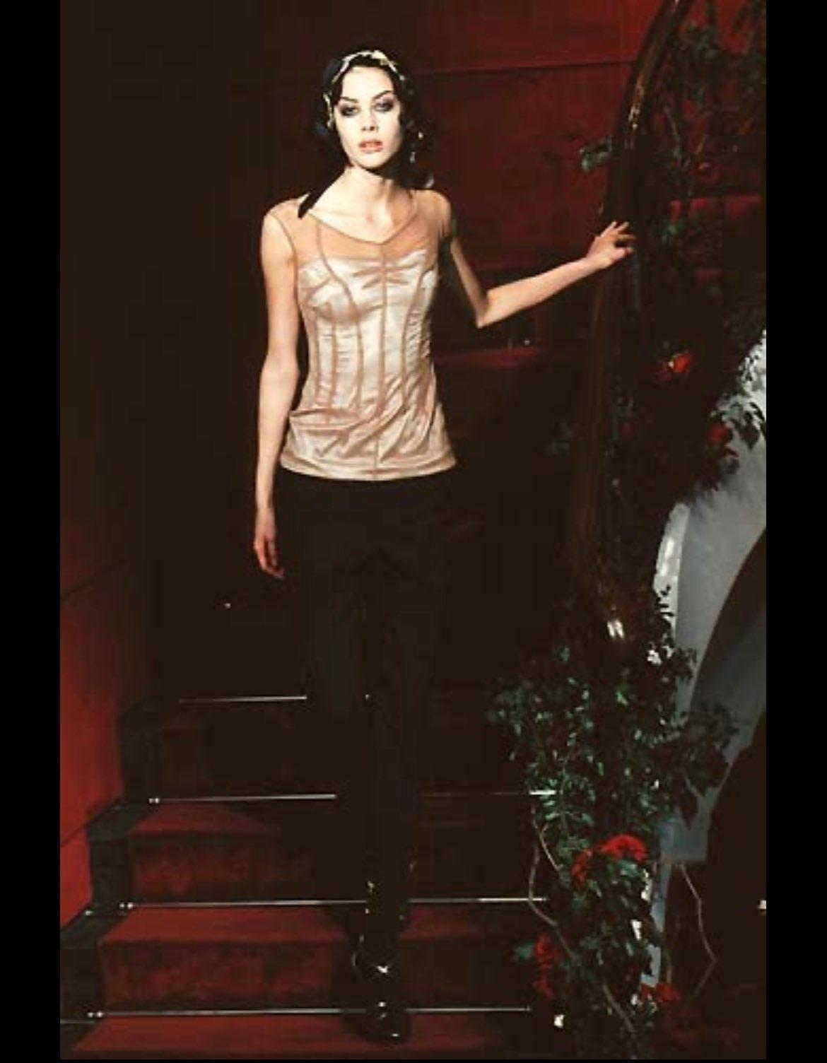 TheRealList presents: a fabulous beige tulle Dolce and Gabbana top. From the Spring/Summer 1998 'Stromboli' collection, this chic top debuted on the season's runway. The top is constructed of an internal satin layer and an external tulle mesh. The
