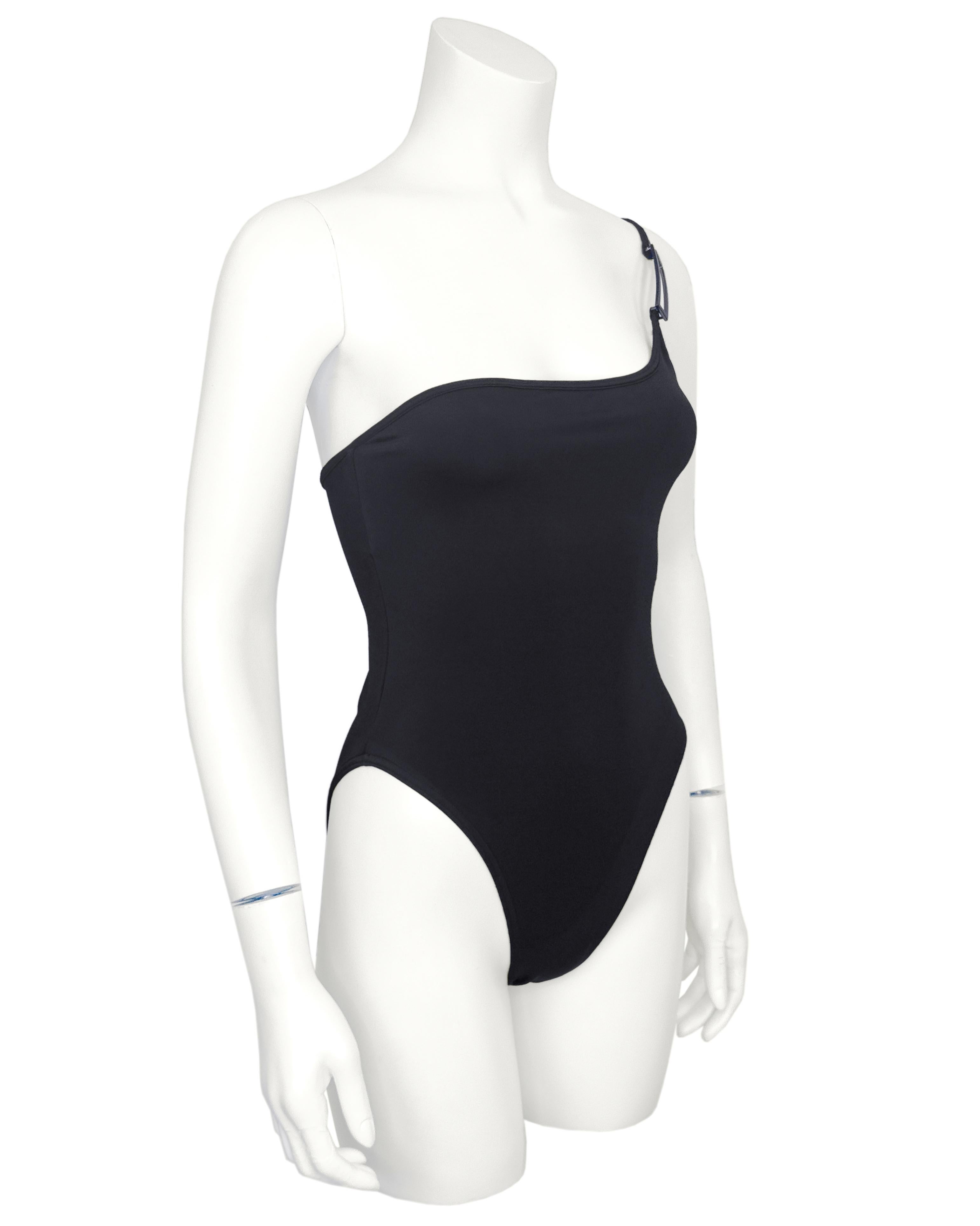 Sleek Gucci by Tom Ford one-shoulder one piece swimsuit from Spring/Summer 1998. Black with a minimalist silhouette elevated by an asymmetrical neckline and a thin strap with a gun metal elongated G buckle detail. Classic Tom Ford for Gucci minimal,