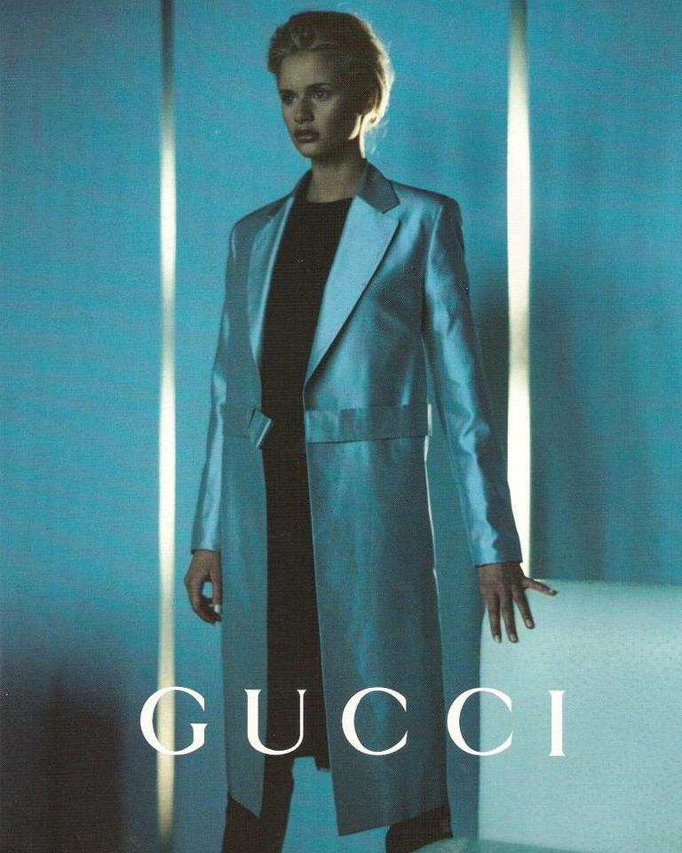 S/S 1998 Gucci by Tom Ford black silk satin jacket. Long sleeve collared blazer jacket with asymmetrical 'bow' detail waist closure, with two interior 'Gucci' stamped buttons. Features monogram black silk lining. Small built-in shoulder pads. As
