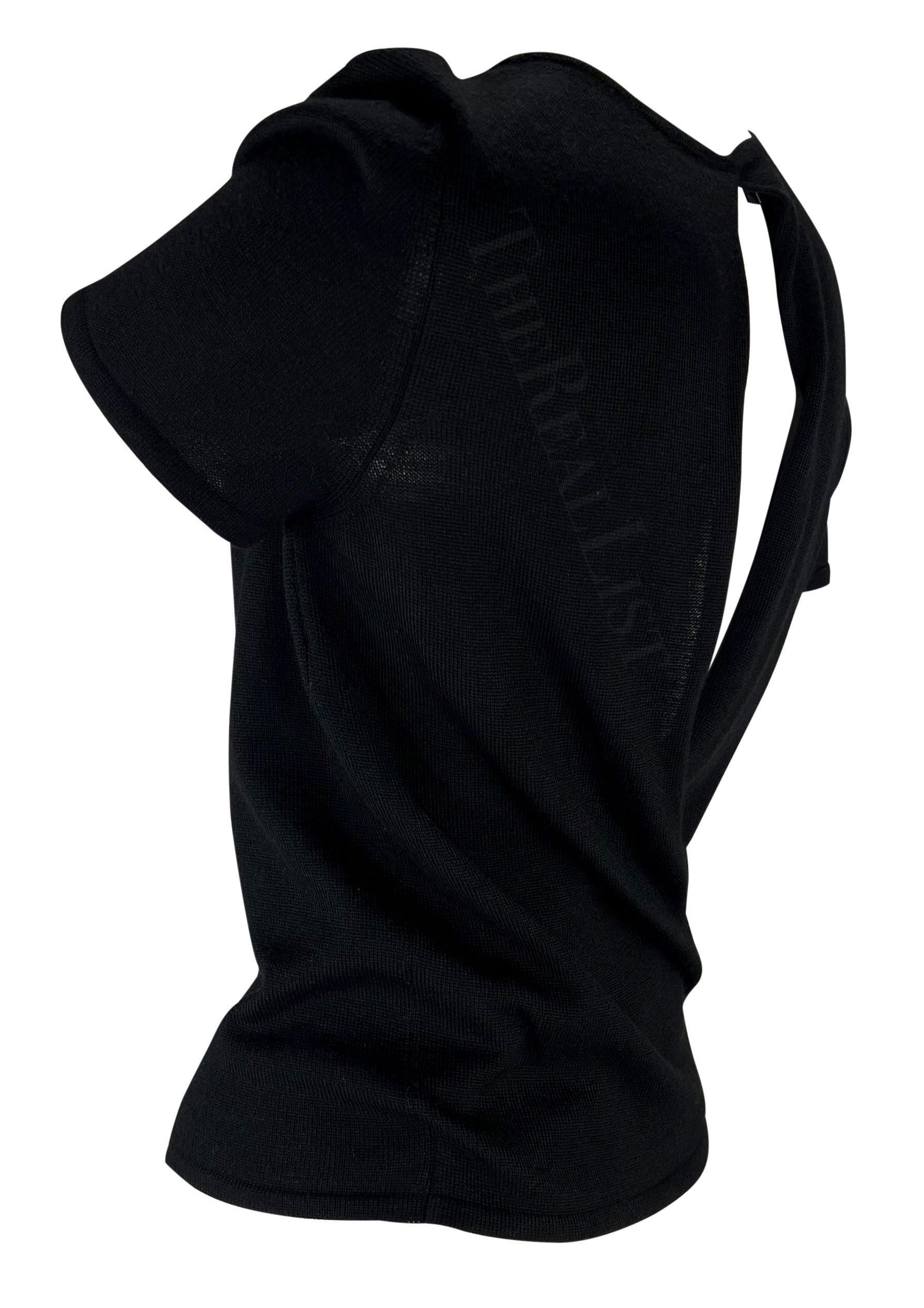 Présentation d'un t-shirt Gucci en maille noire, dessiné par Tom Ford. Issu de la collection printemps-été 1998, ce haut présente des détails perforés et s'enroule dans le dos en créant un œillet qui dévoile le dos. Ce top Gucci by Tom Ford est