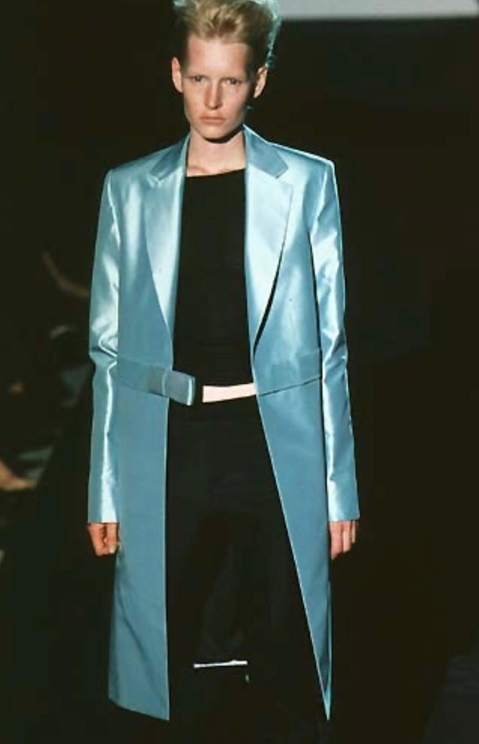 Voici une superbe jupe Gucci en satin bleu layette, dessinée par Tom Ford. Dans la collection printemps/été 1998, le même satin bleu bébé est apparu sur le podium sur une veste et un pantalon. Entièrement réalisée en satin, cette jupe brille