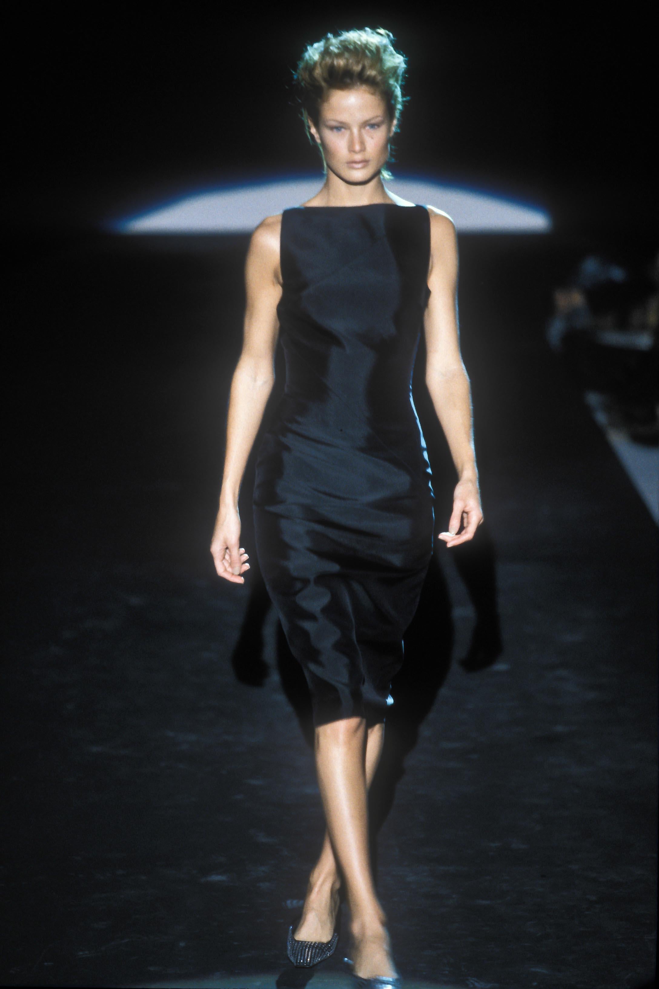 This black silk satin Gucci dress, designed by Tom Ford for the Spring/Summer 1998 collection, debuted on the runway on Carolyn Murphy and was featured in the season's ad campaign photographed by Luis Sanchis. The dress highlights Ford's signature