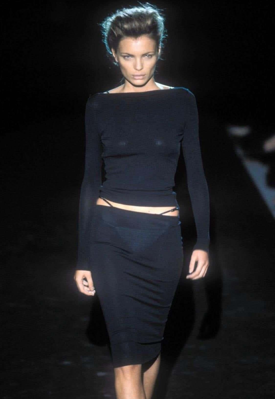 Die Präsentation eines der ikonischsten Designs von Tom Ford bei Gucci. Dieses atemberaubende langärmelige Oberteil kann auf zwei Arten getragen werden: mit offenem Rücken oder mit einem U-Ausschnitt (ein Trend, den auch Bella Hadid trägt). Dieses