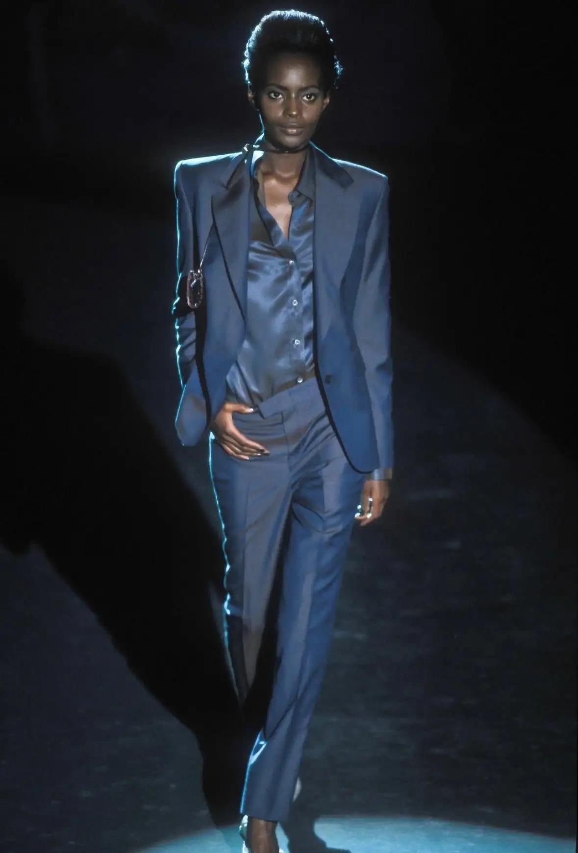 Diese exquisite Button-up-Bluse wurde von Tom Ford für die Frühjahr/Sommer-Kollektion 1998 von Gucci entworfen und besticht durch ihre schillernde Qualität. Mit seinen tiefroten Untertönen, die bei jeder Bewegung subtil durch den dunkelgrauen Stoff