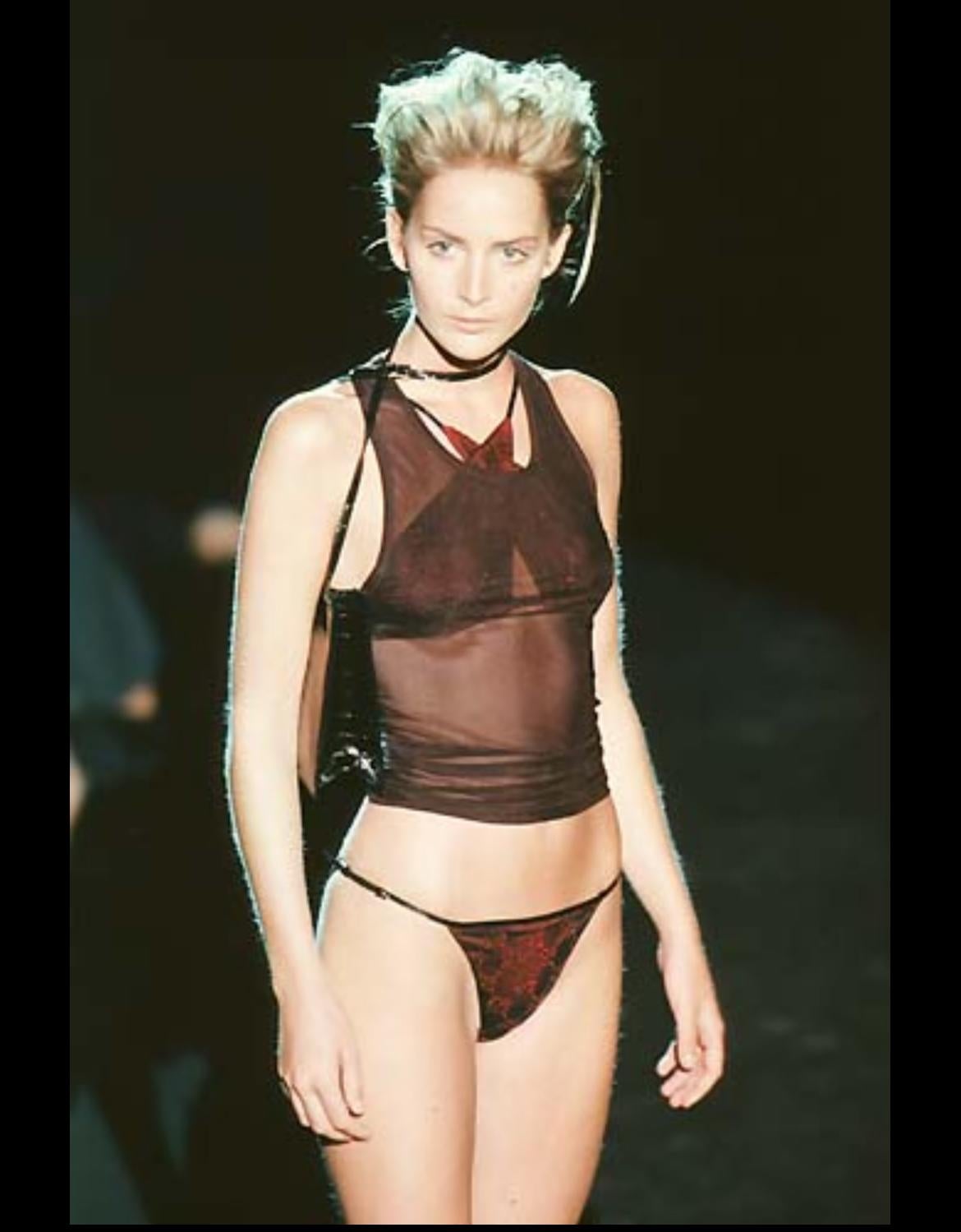 From Gucci’s Spring/Summer 1998 collection under Tom Ford, this sheer black mesh tank top features a minimalist scoop neckline and body-hugging silhouette. Designed to reveal and contour, the piece debuted on the runway as part of Ford’s