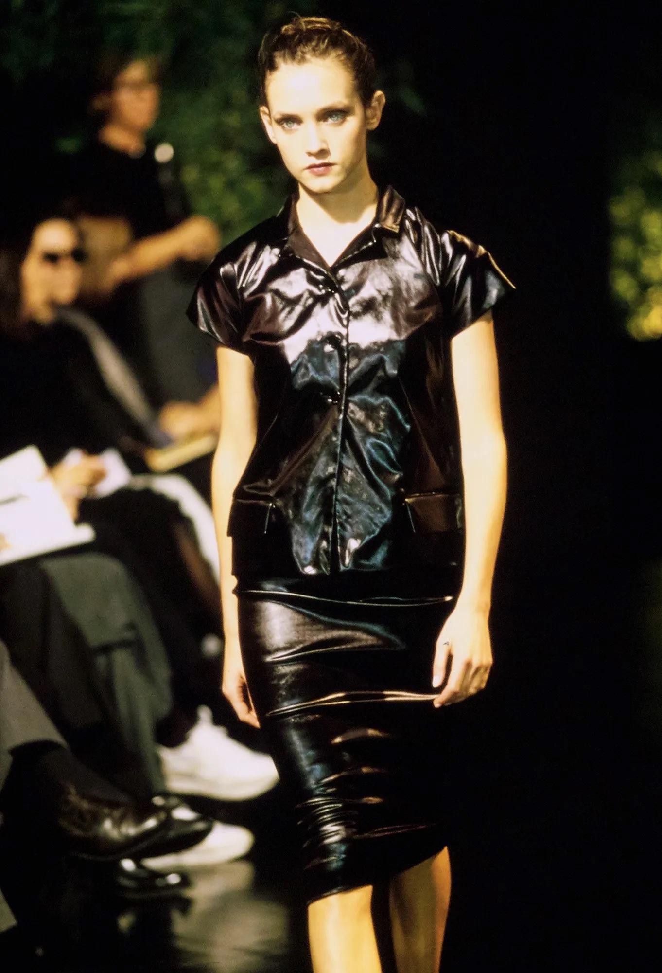 This fabulous black satiny Dolce & Gabbana short sleeve button-down top was featured in the Spring/Summer 1999 'Sicily Through the Internet' collection. It debuted on the season's runway as part of look 33, worn by model Lida Egorova. This