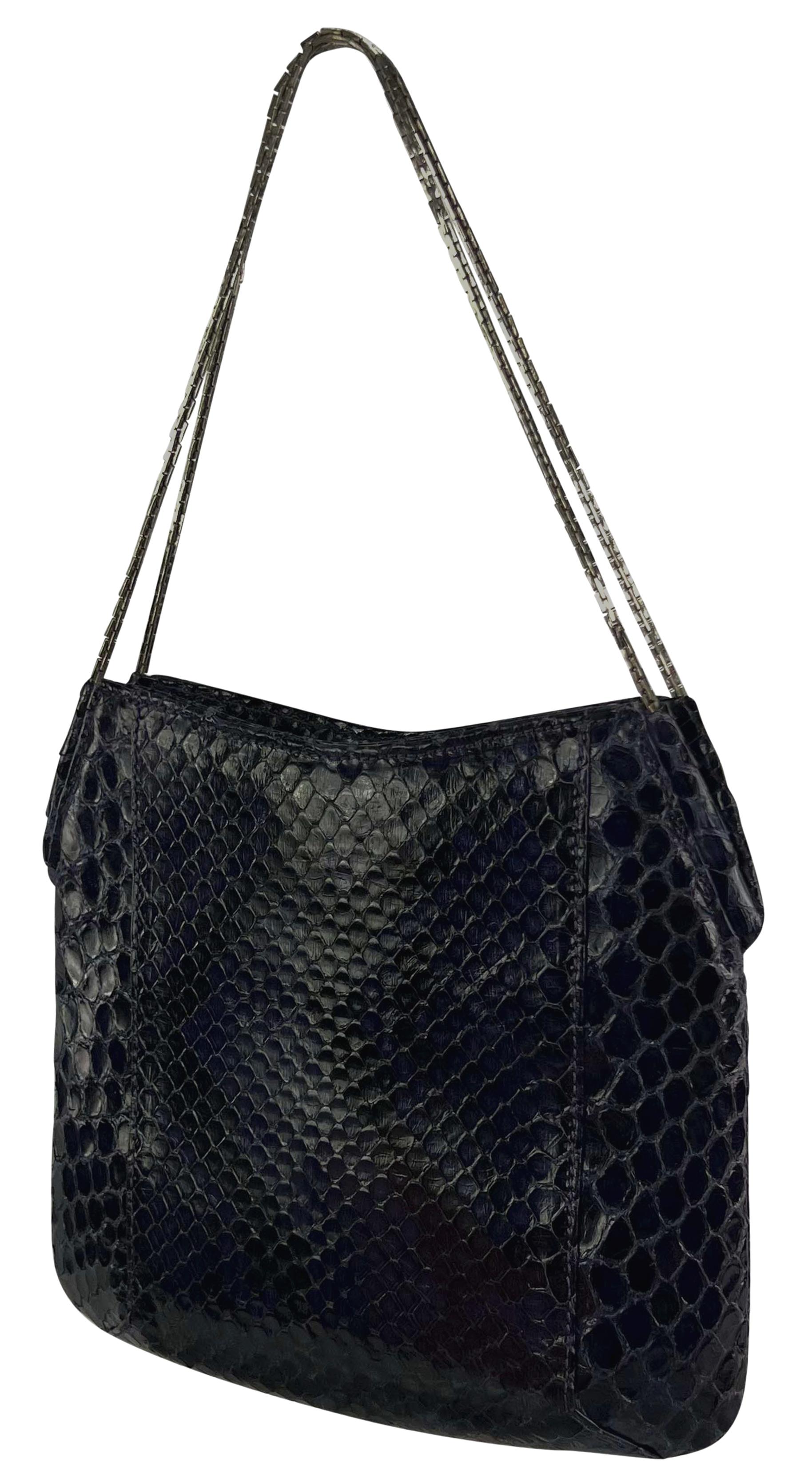 Cet incroyable mini sac en python violet foncé de Gianni Versace, dessiné par Donatella Versace, est issu de la collection automne/hiver 1999. Il est en cuir de python violet luxueux et doté d'une anse en chaîne argentée.

Mesures approximatives