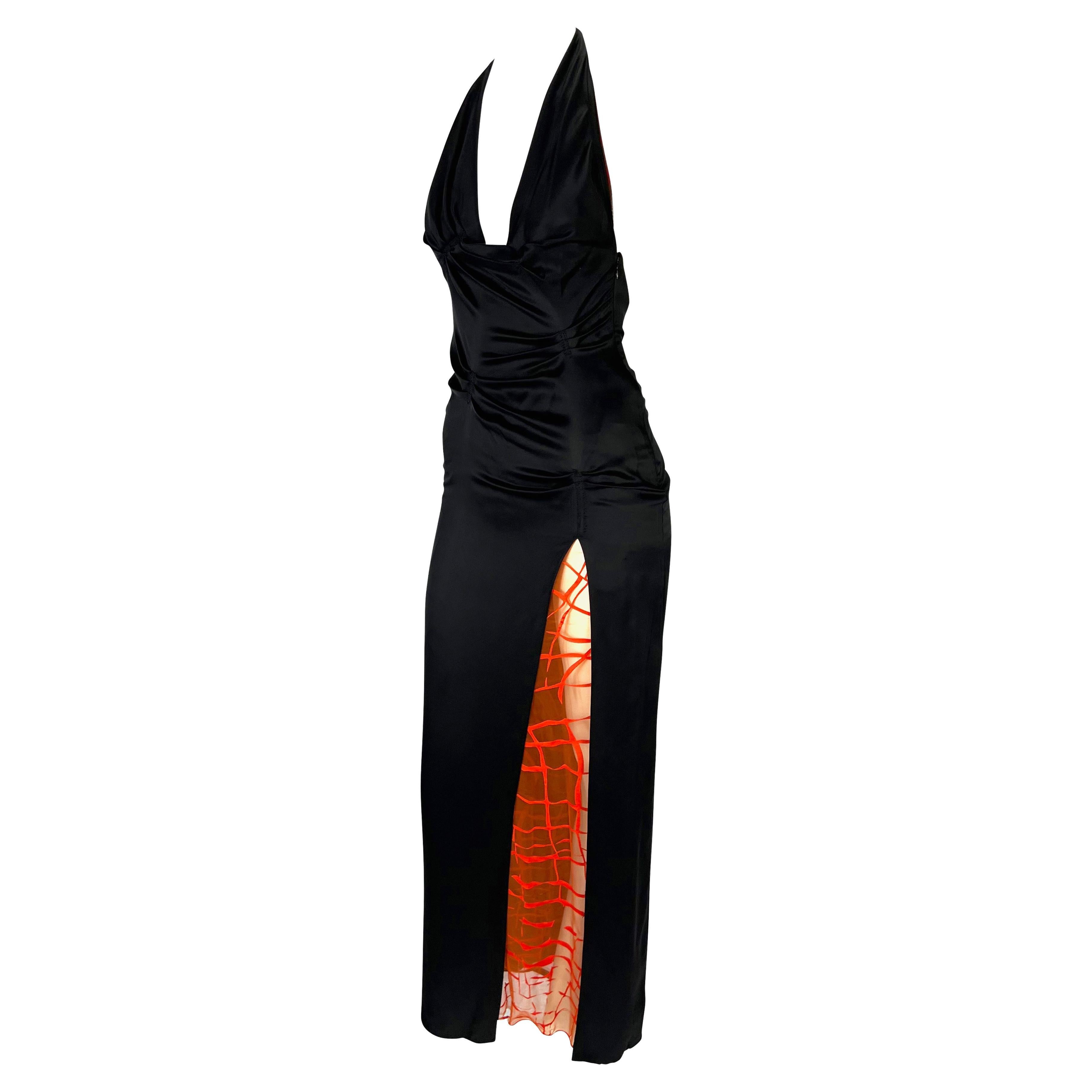 Presenting a stunning black and orange Gianni Versace halterneck gown, designed by Donatella Versace. From the Spring/Summer 1999 collection, this beautiful dress features ruching throughout the torso, a halterneck, an exposed back, and an angular