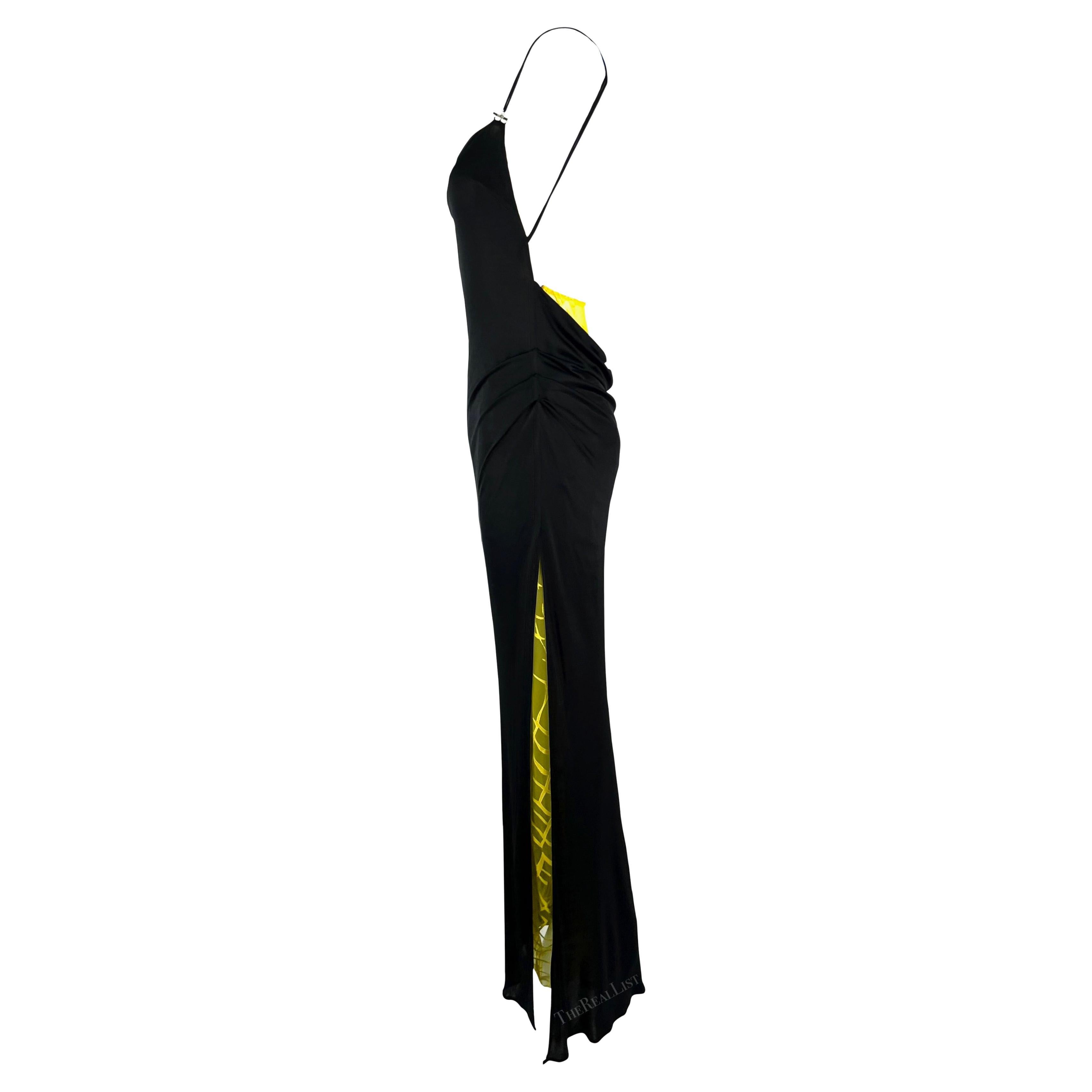 Presenting a fabulous black slip gown by Gianni Versace, designed by Donatella Versace for the Spring/Summer 1999 collection. This gown showcases spaghetti straps adorned with metal hardware accents and an exposed back. At the back, there is also a