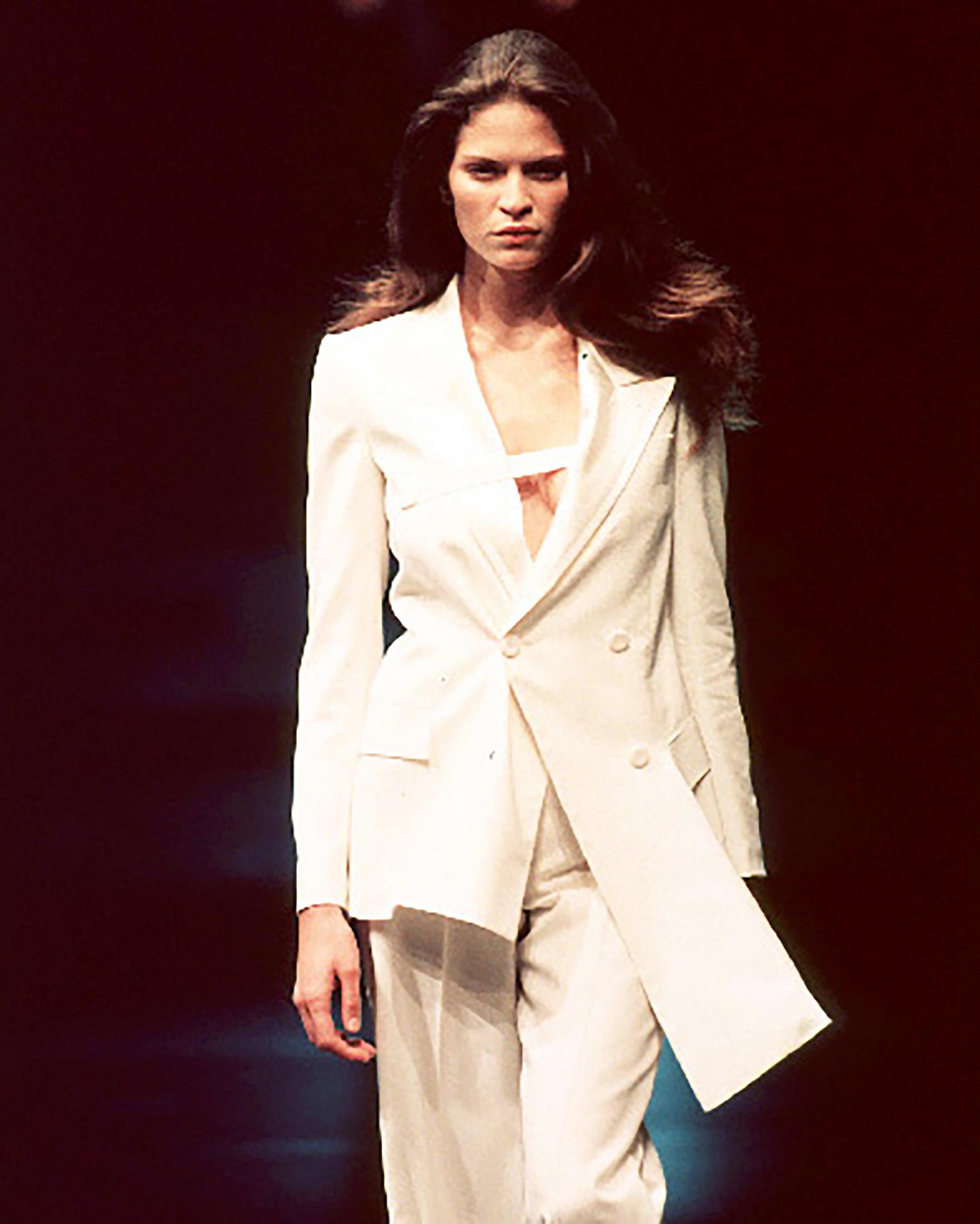 S/S 1999 Givenchy Couture by Alexander McQueen cream tuxedo blazer with asymmetrical hem. Double-breasted wool blazer with structured white silk lapel panels and three light cream shell button closures. Opening look on the runway, and seen in the ad