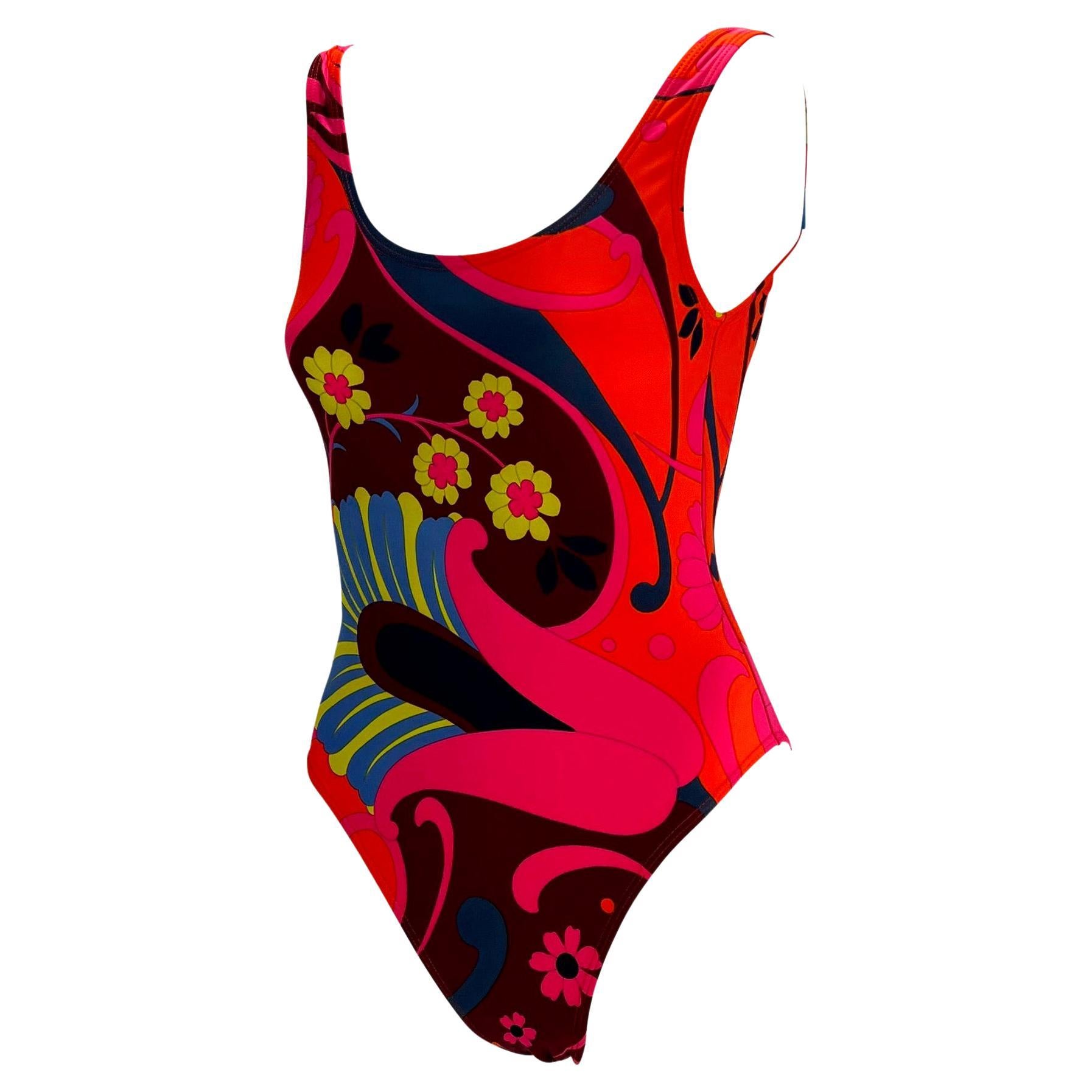 Presenting a gorgeous groovy floral one piece Gucci swimsuit, designed by Tom Ford. From the Spring/Summer 1999 collection, this swimsuit sports a bold hippy inspired print. Featuring a pink/orange floral motif, this one piece is made complete with