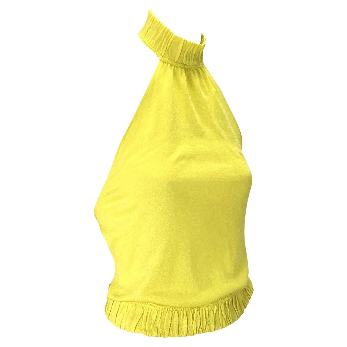Présentation d'un top en maille Gucci jaune électrique, dos nu, dessiné par Tom Ford. Issu de la collection printemps/été 1999, ce top en soie semi-transparente est composé de trois bandes extensibles qui s'ajustent autour du cou, du milieu du dos