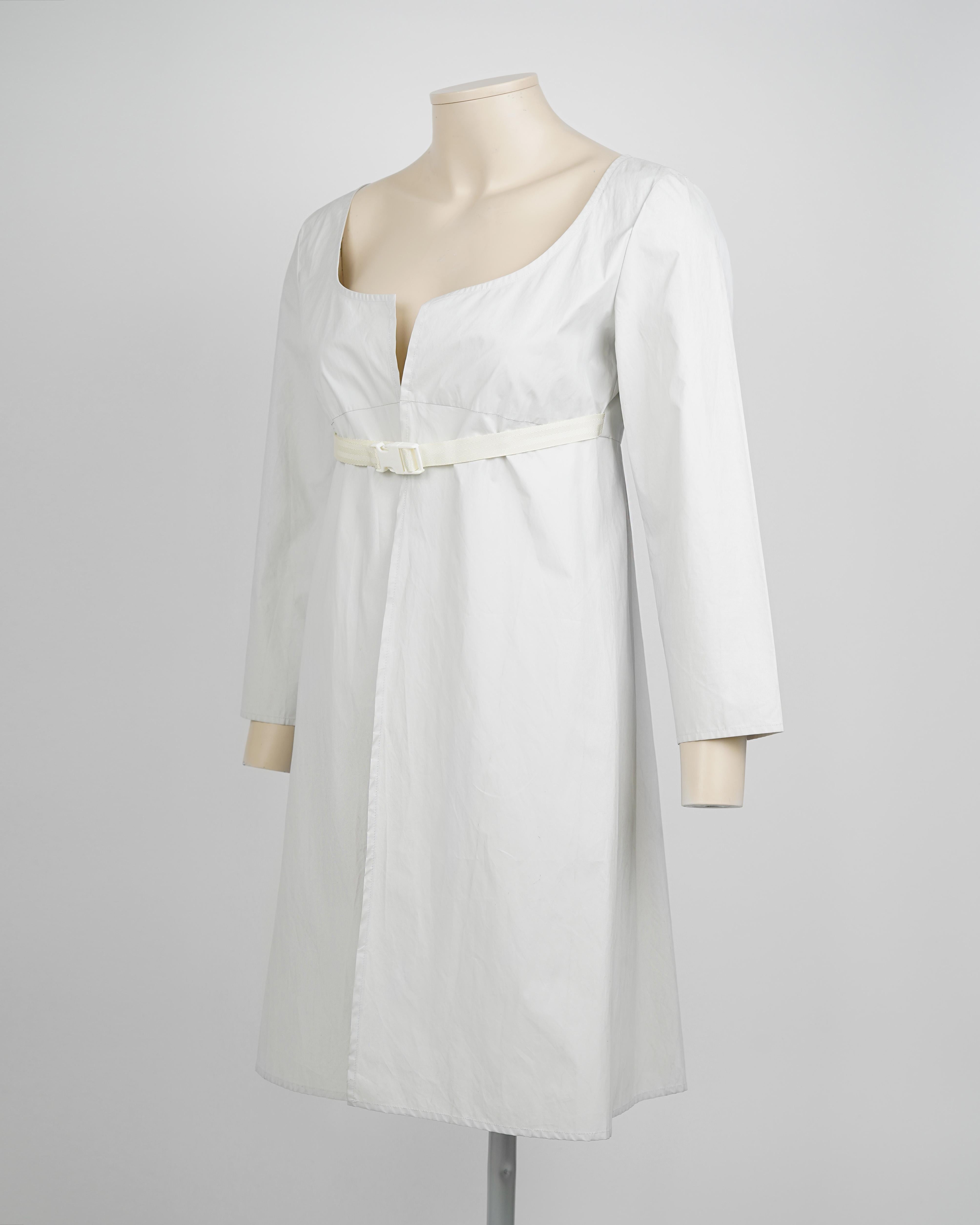 Pièce rare et emblématique de la collection printemps-été 1999 de Miu Miu, cette robe technique ceinturée est un exemple frappant du minimalisme de la fin des années 90, interprété à travers une coupe précise et une forme architecturale.