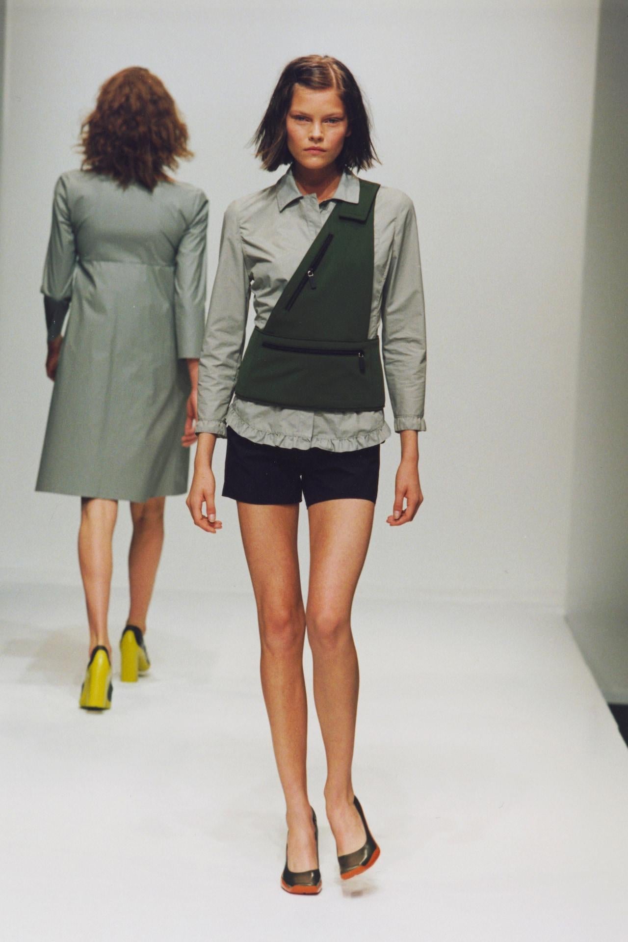 Ce sac asymétrique vert olive de la collection printemps/été 1999 de Miu Miu est un exemple frappant de l'esprit avant-gardiste et utilitaire de Miuccia Prada à la fin du millénaire. À la fois conceptuelle et fonctionnelle, cette pièce brouille la
