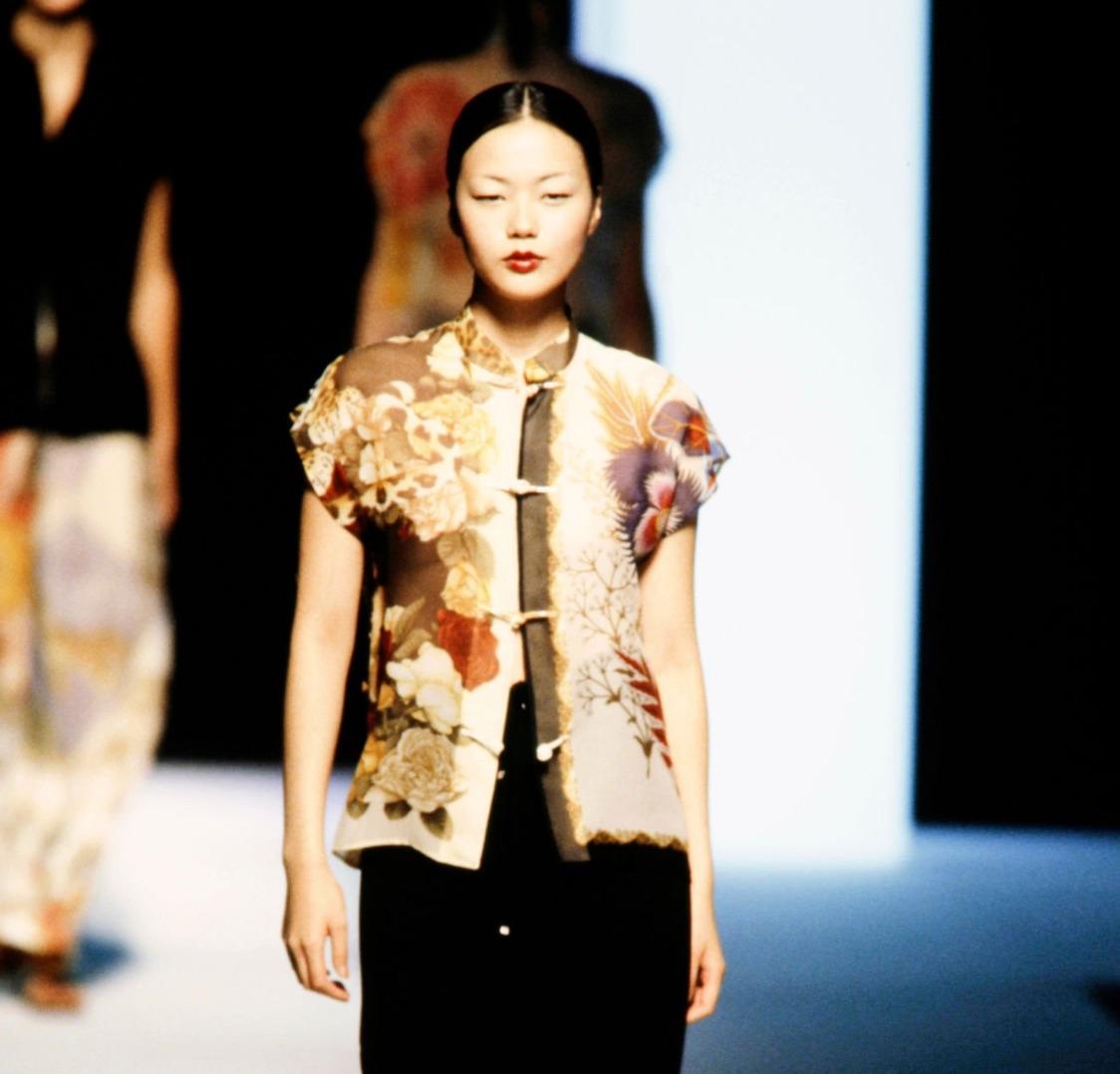 Issue de la collection printemps/été 1999 de Salvatore Ferragamo, cette blouse en soie transparente a fait ses débuts sur le podium et a été reprise dans la campagne publicitaire de la saison. Ce modèle, qui présente un motif floral et fruitier dans