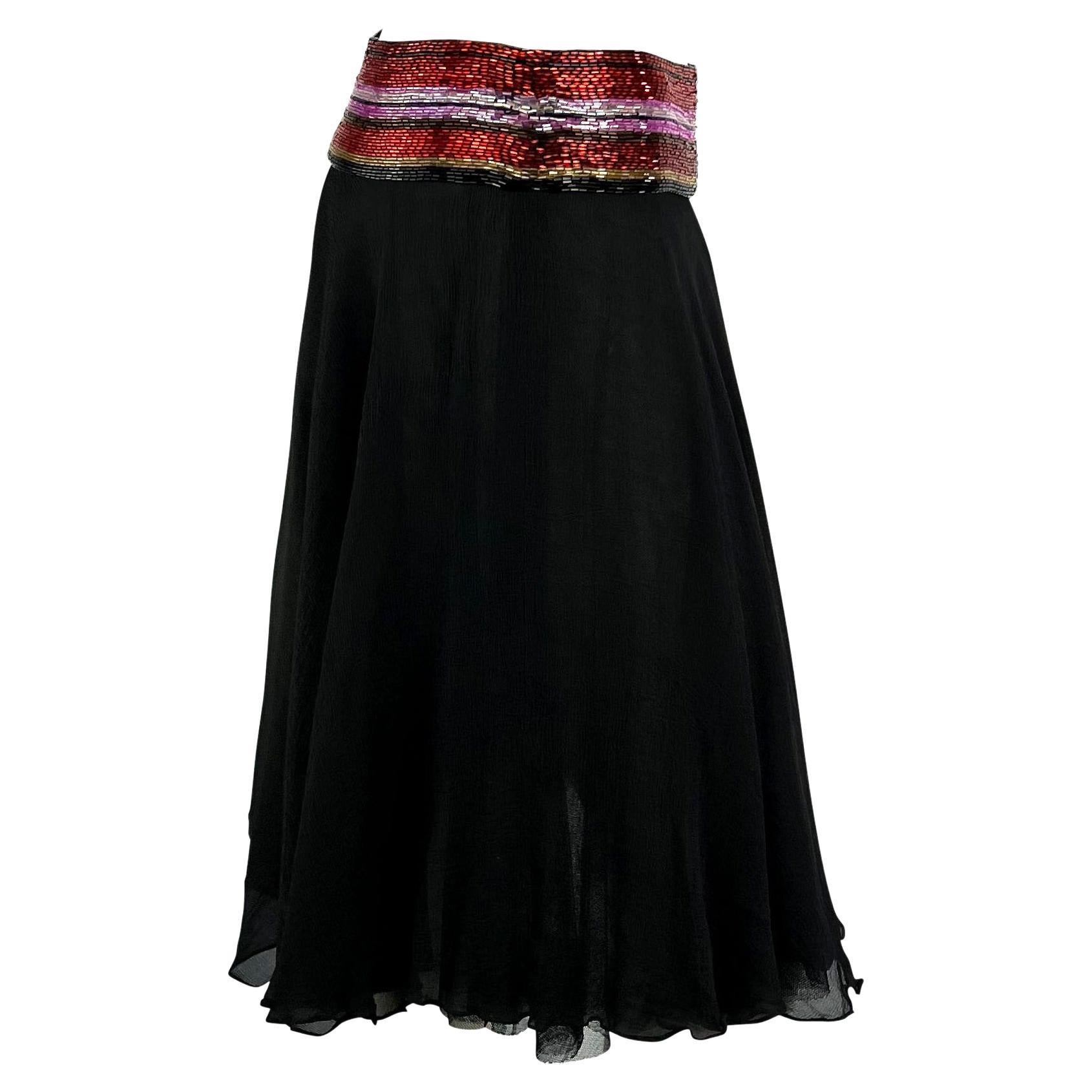 Presenting a stunning beaded Dolce and Gabbana skirt. This skirt is composed primarily of black silk chiffon and is made complete with a band of colorful red, purple, and black beads. From the Spring/Summer 2000 collection, this beautiful skirt was